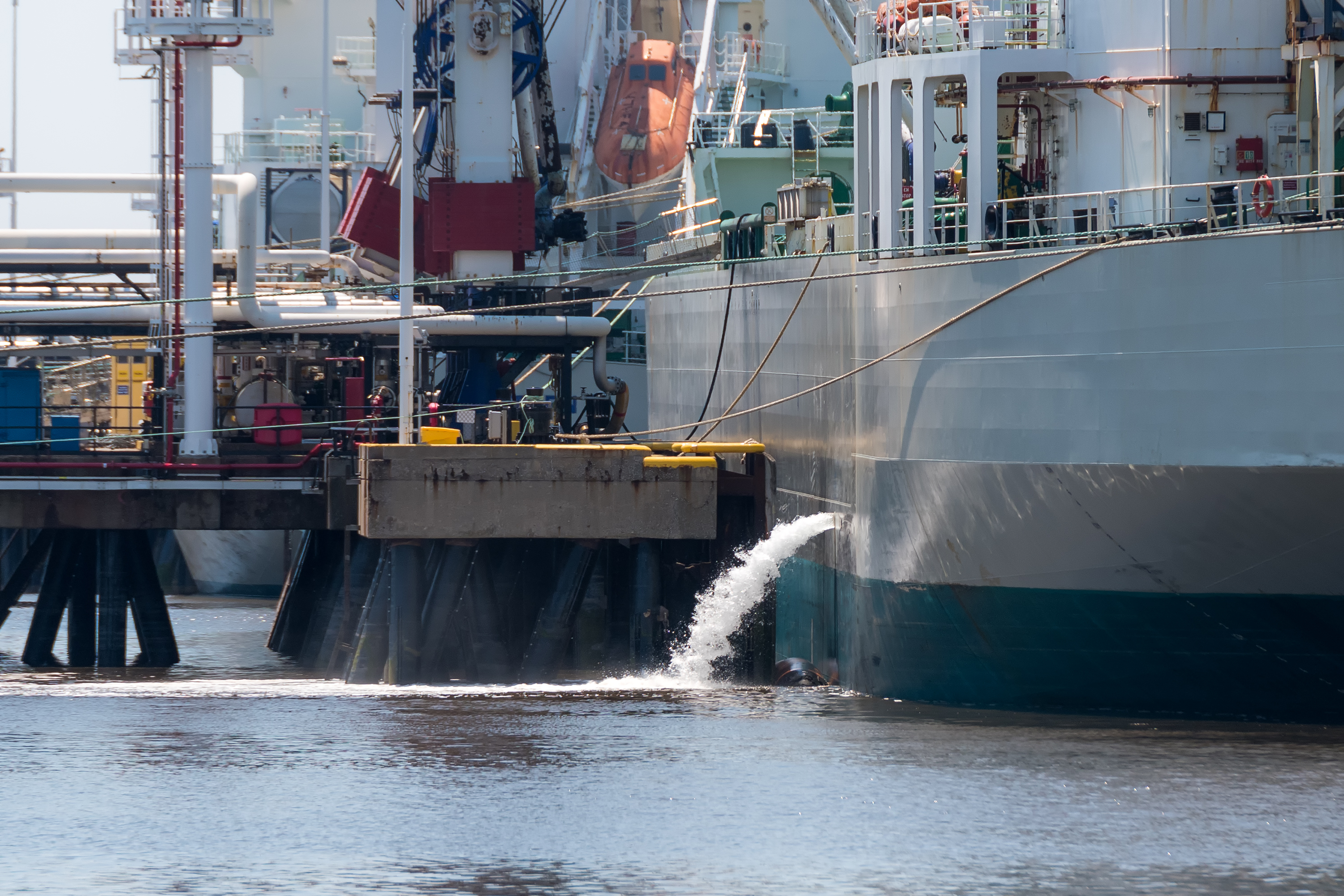 A ship emptying its ballast tank at a dock.