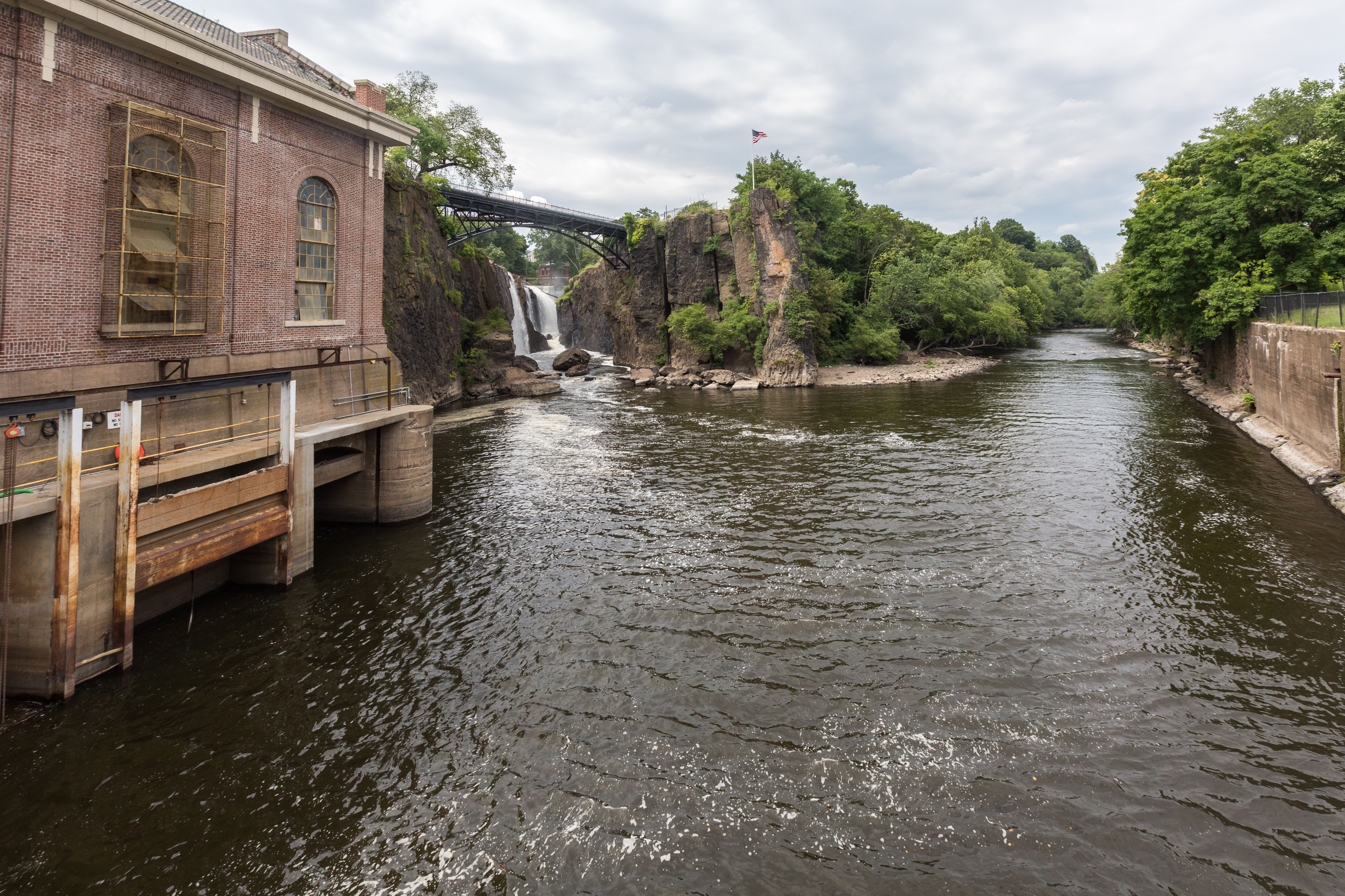 A view of Paterson falls with an aging building next to it.