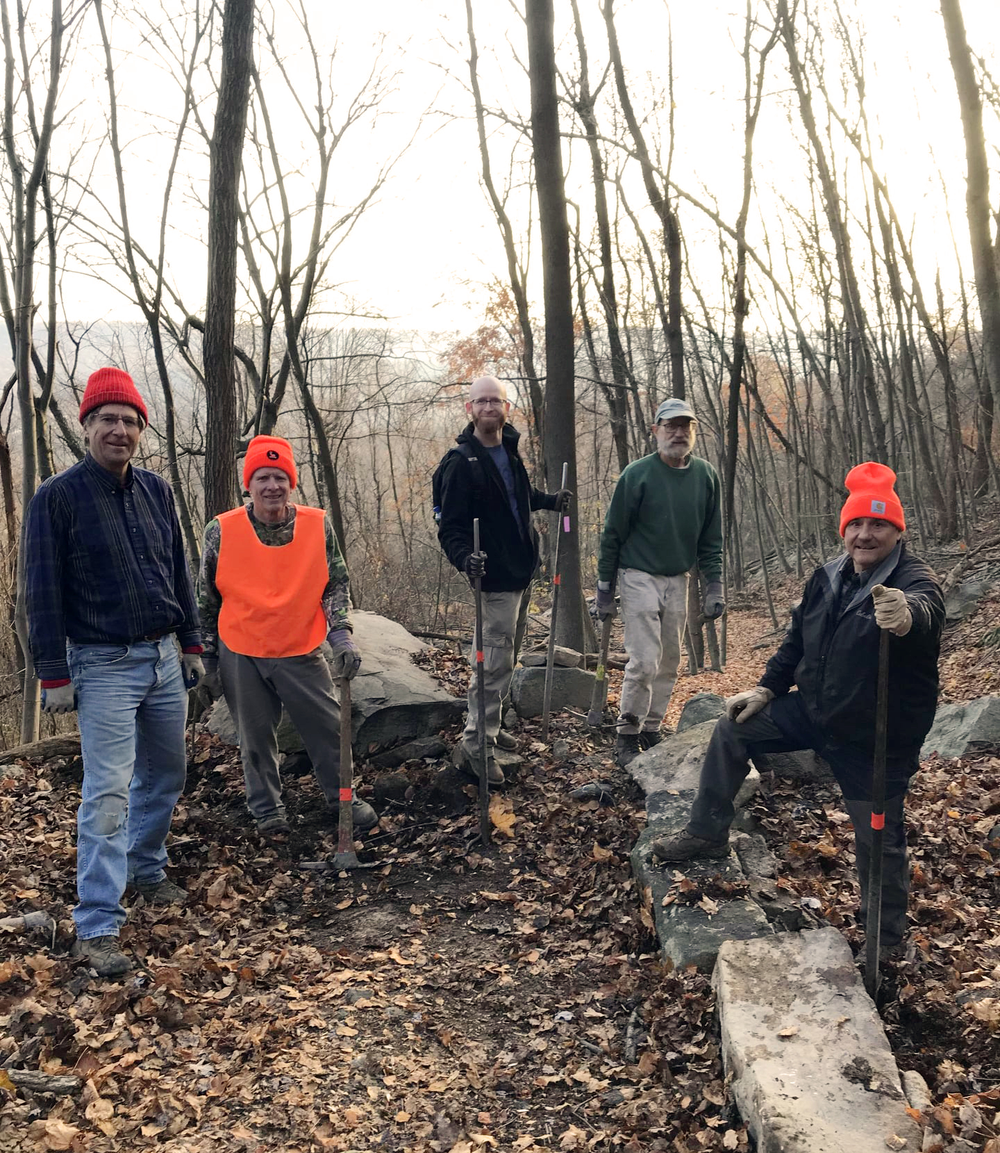 A group of five men pause during a volunteer workday.