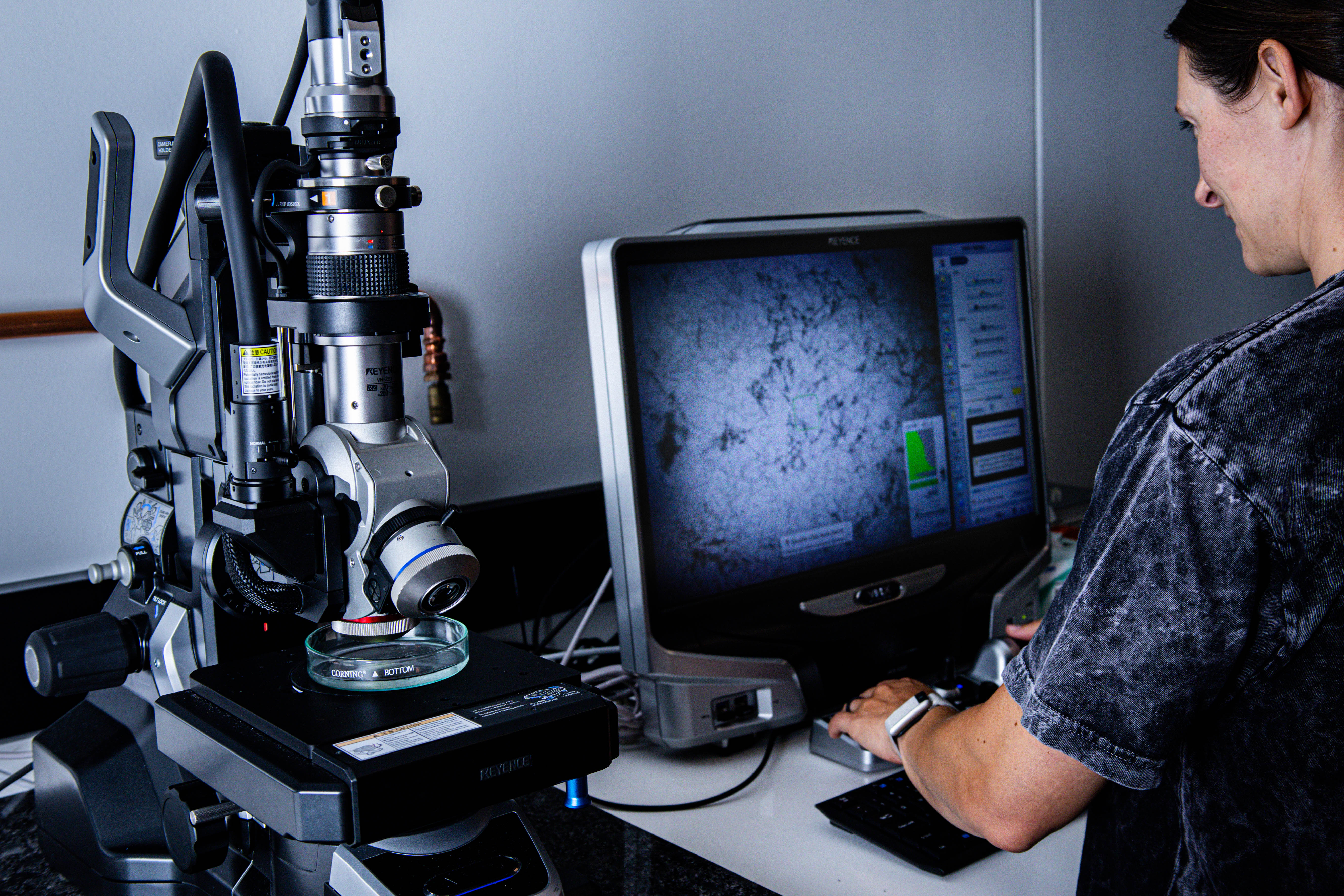 Someone looks under a microscope at microfibers. 