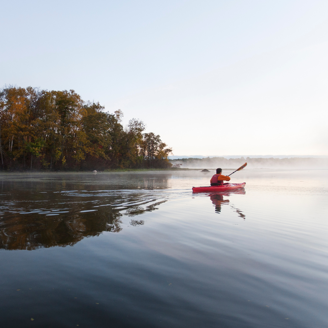 A kayak in a still river.