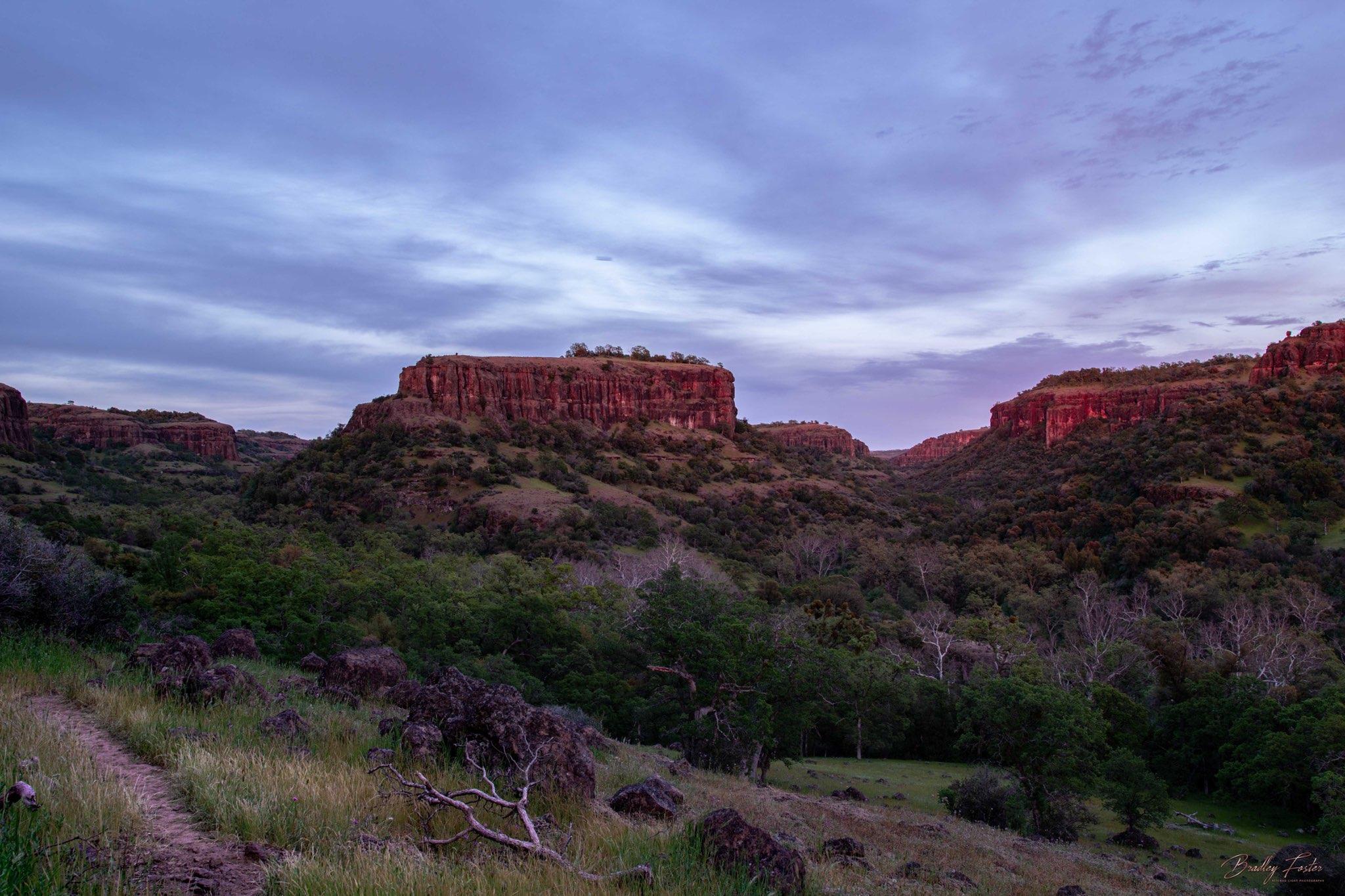 Rocky outcroppings and wodded landscape of Campo Seco in the evening twilight.