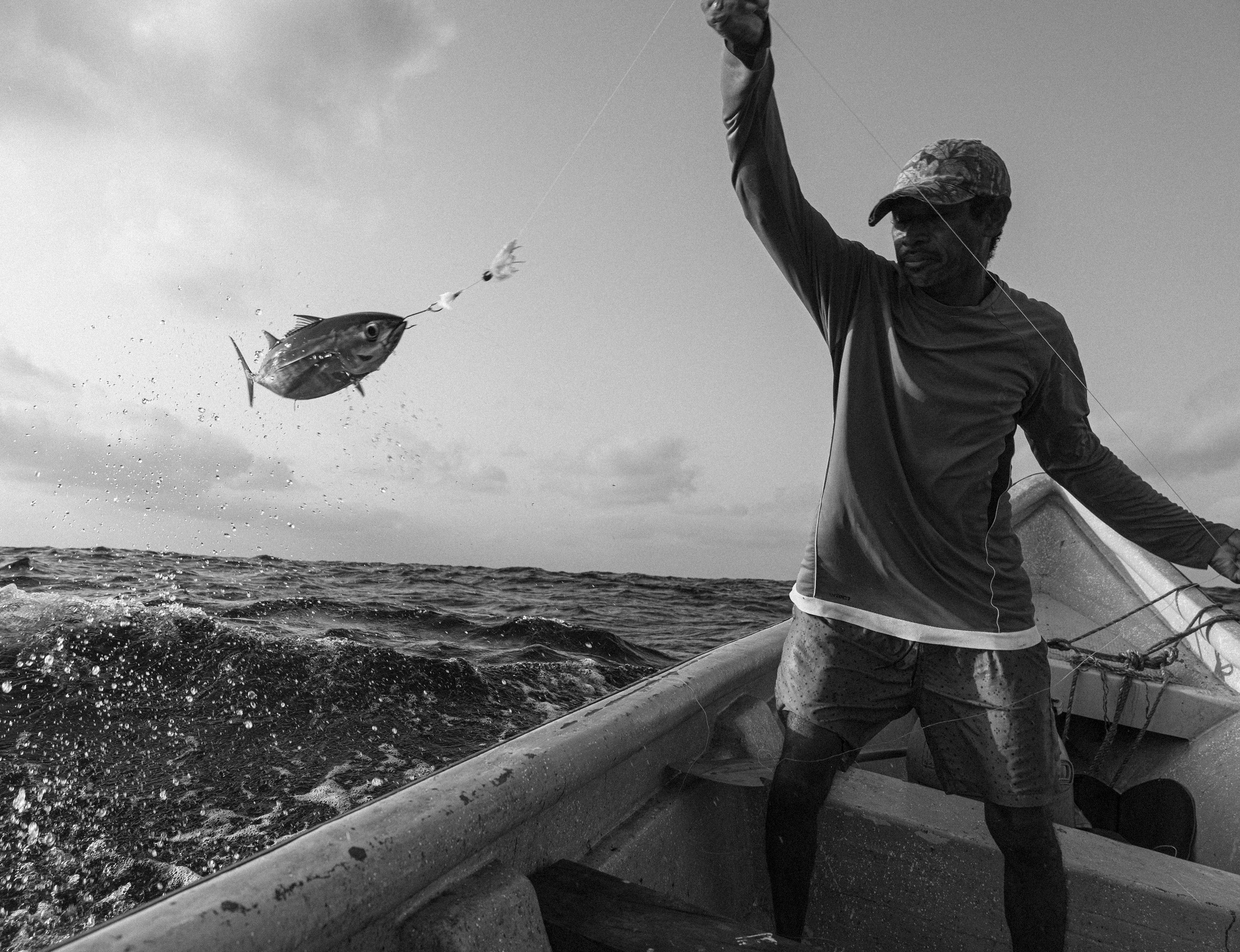 A Colombian fisher pulls a fish out of the water. 