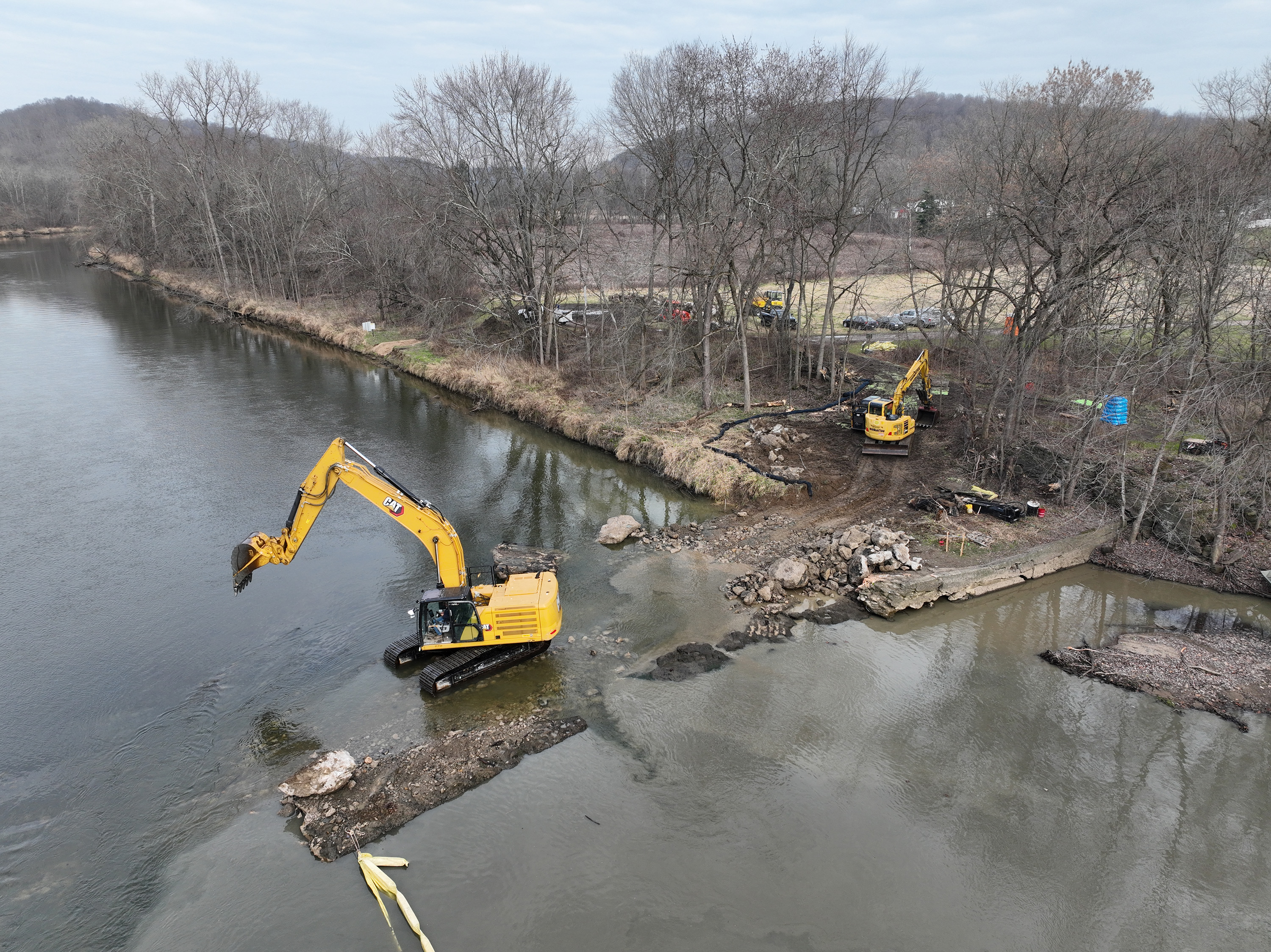 Aerial view of construction equipment working to remove dam in river.