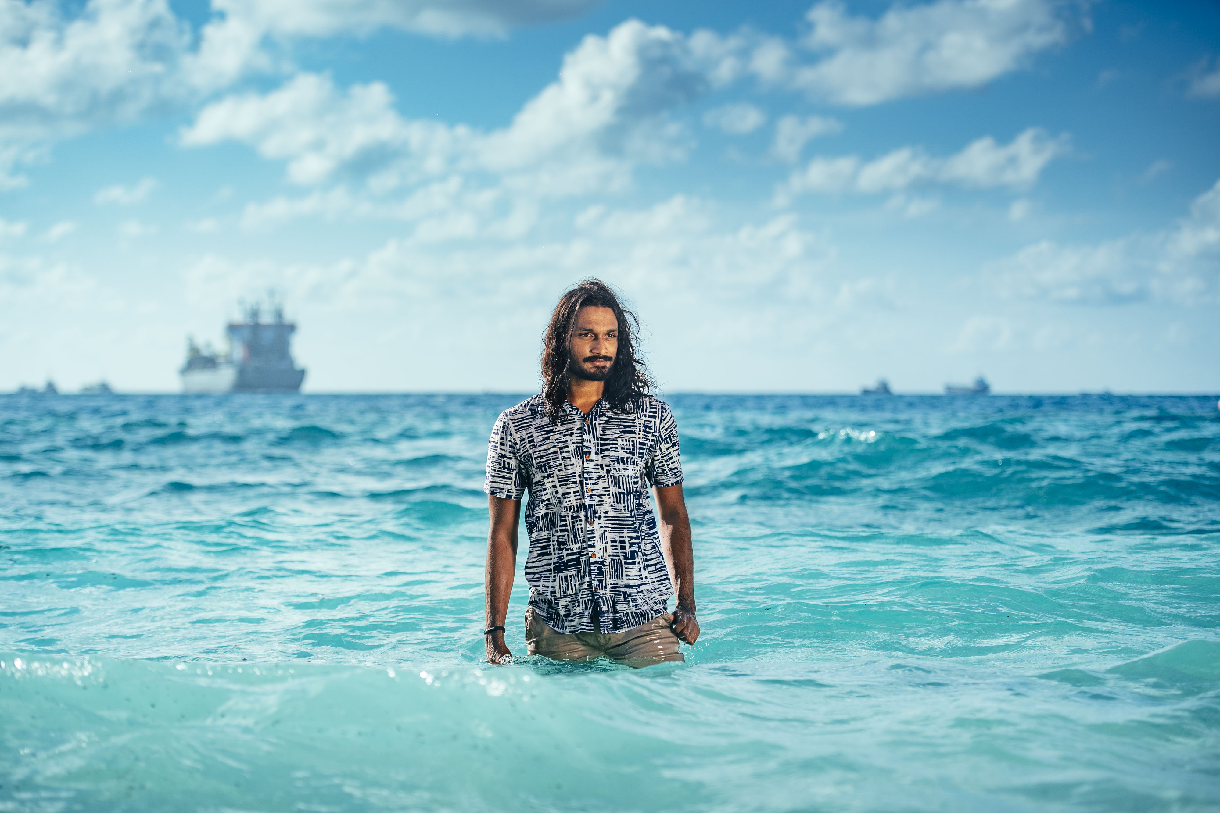 Ijunad Junaid stand in the water at Villingili Beach, Maldives.
