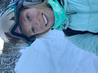 Woman in winter gear on snowy slope.