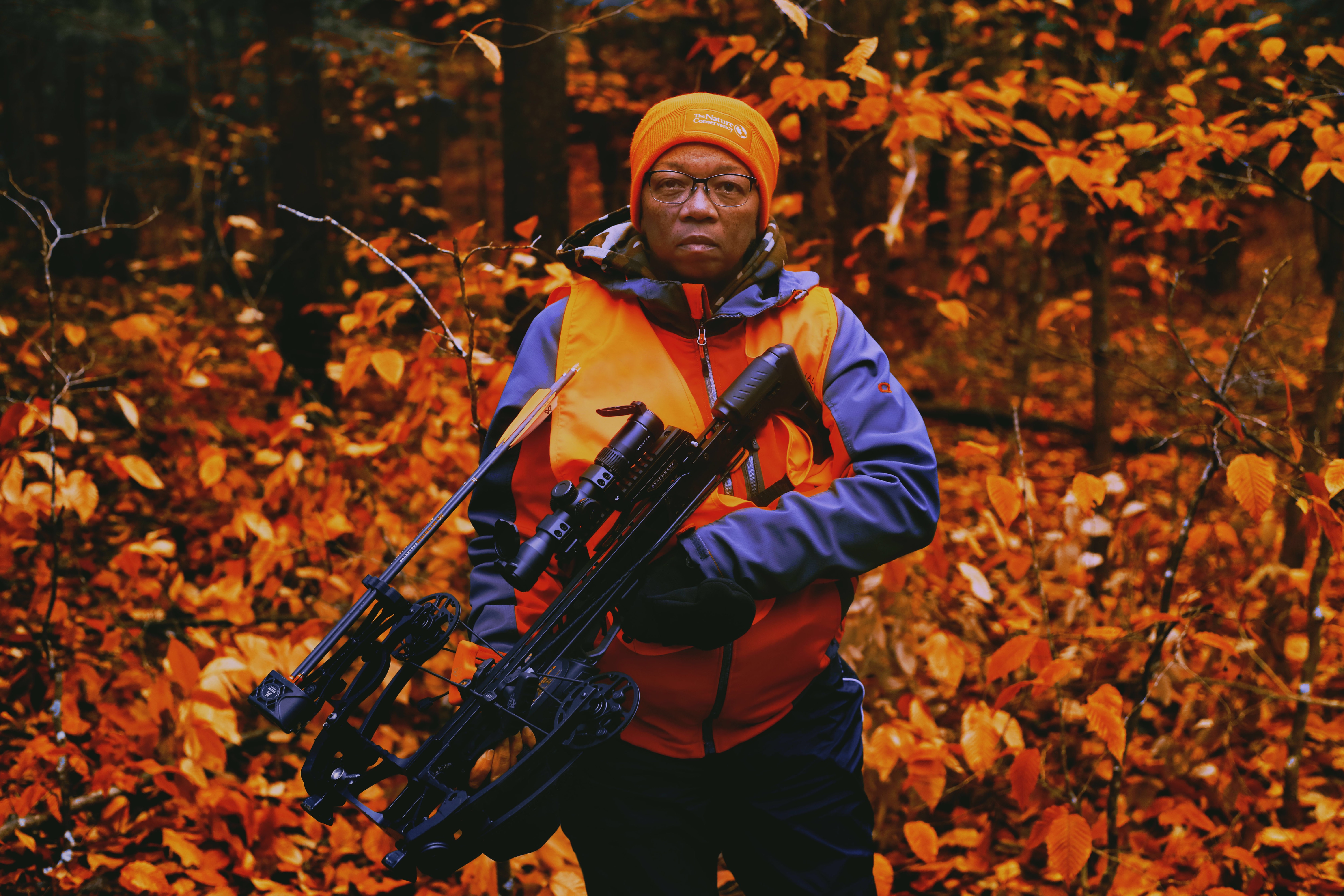 A photo of Benita Law-Diao holding hunting equipment.