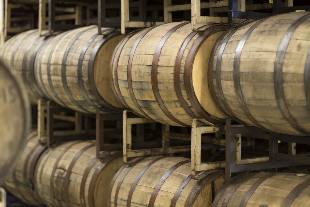 Wooden beer kegs on side on rack.