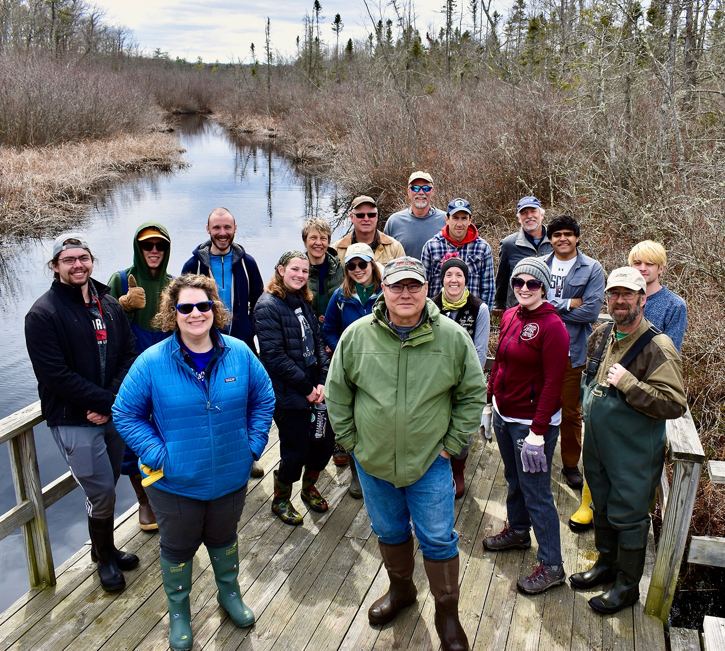 A group of volunteers standing on a boardwalk.