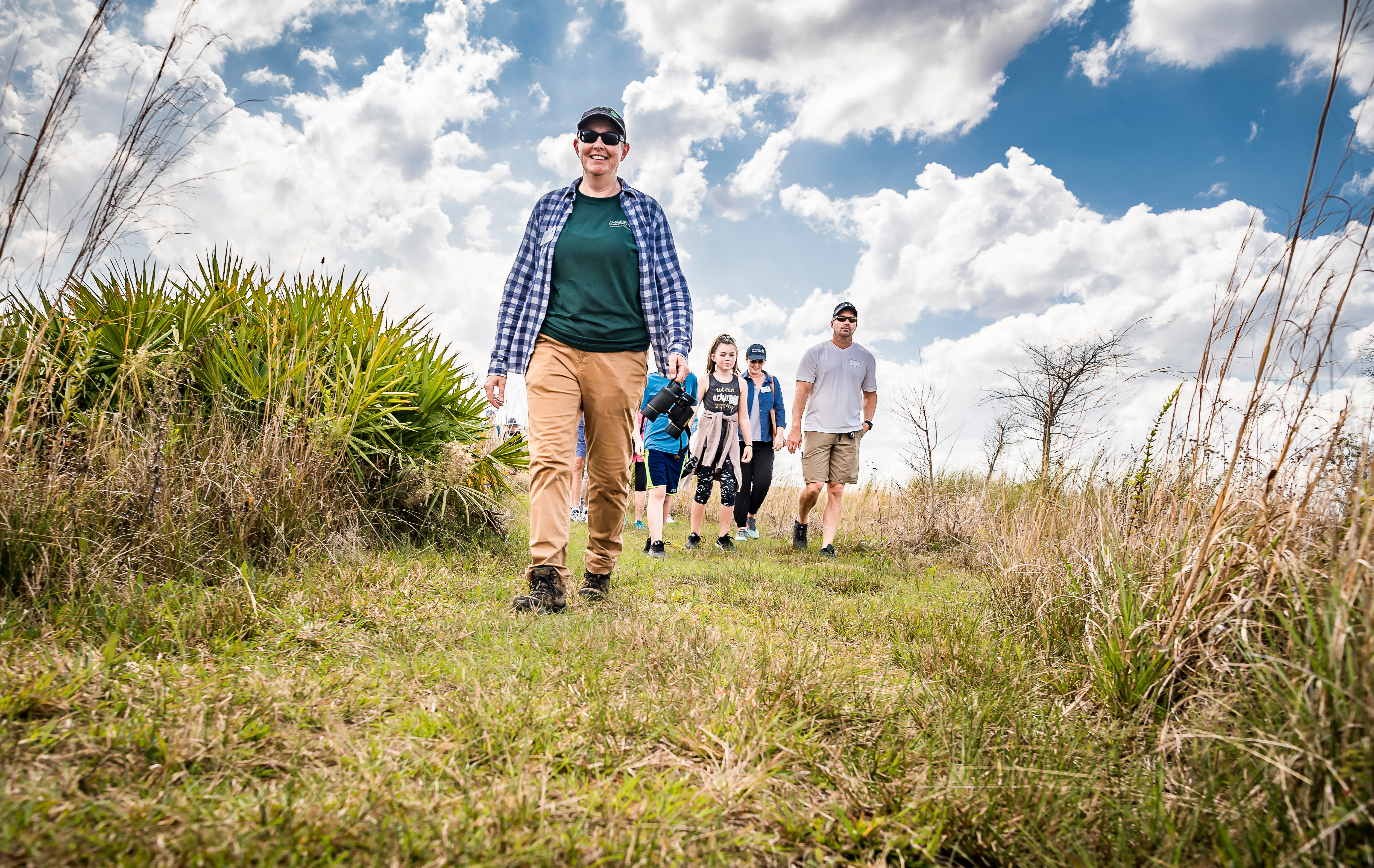 A group of people hike along a trail.