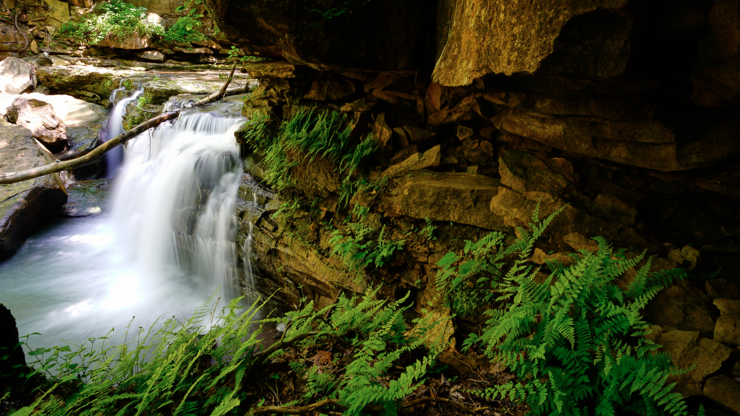 A rushing waterfall over a rocky outcrop. 