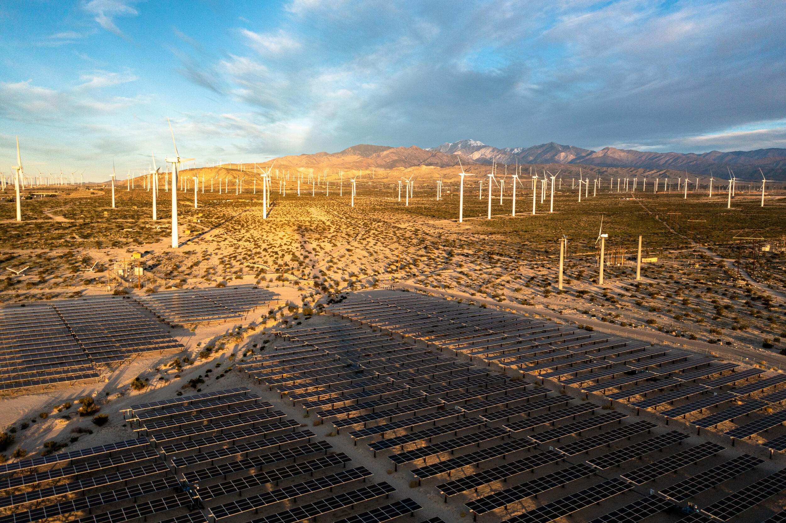 desert landscape with solar panels and wind turbines