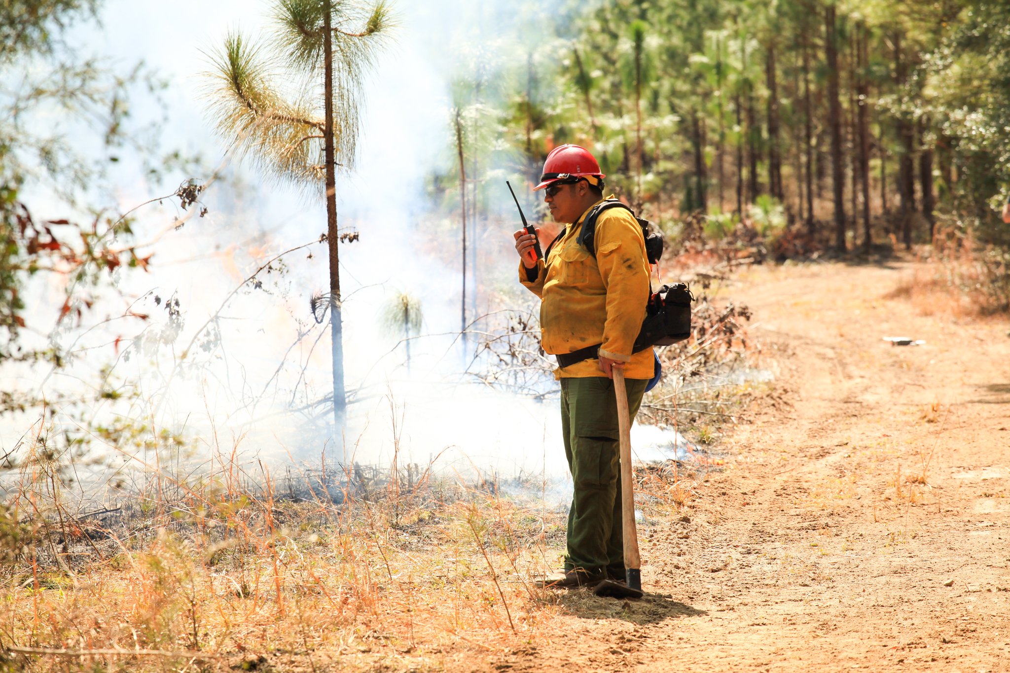 Gesse Bullock speaks into a radio during a burn.