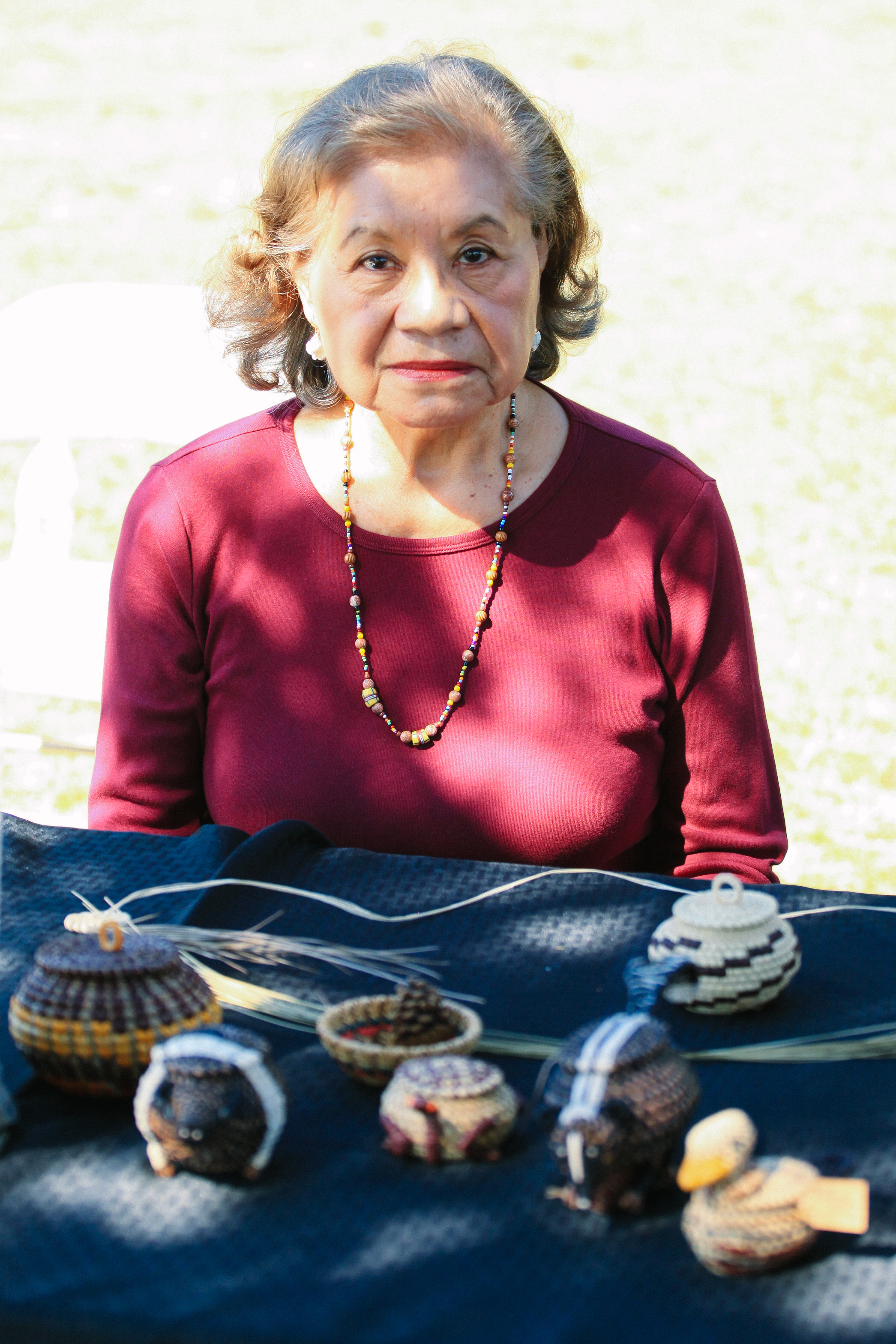 Gladys Shutt sits with her woven baskets and creations.