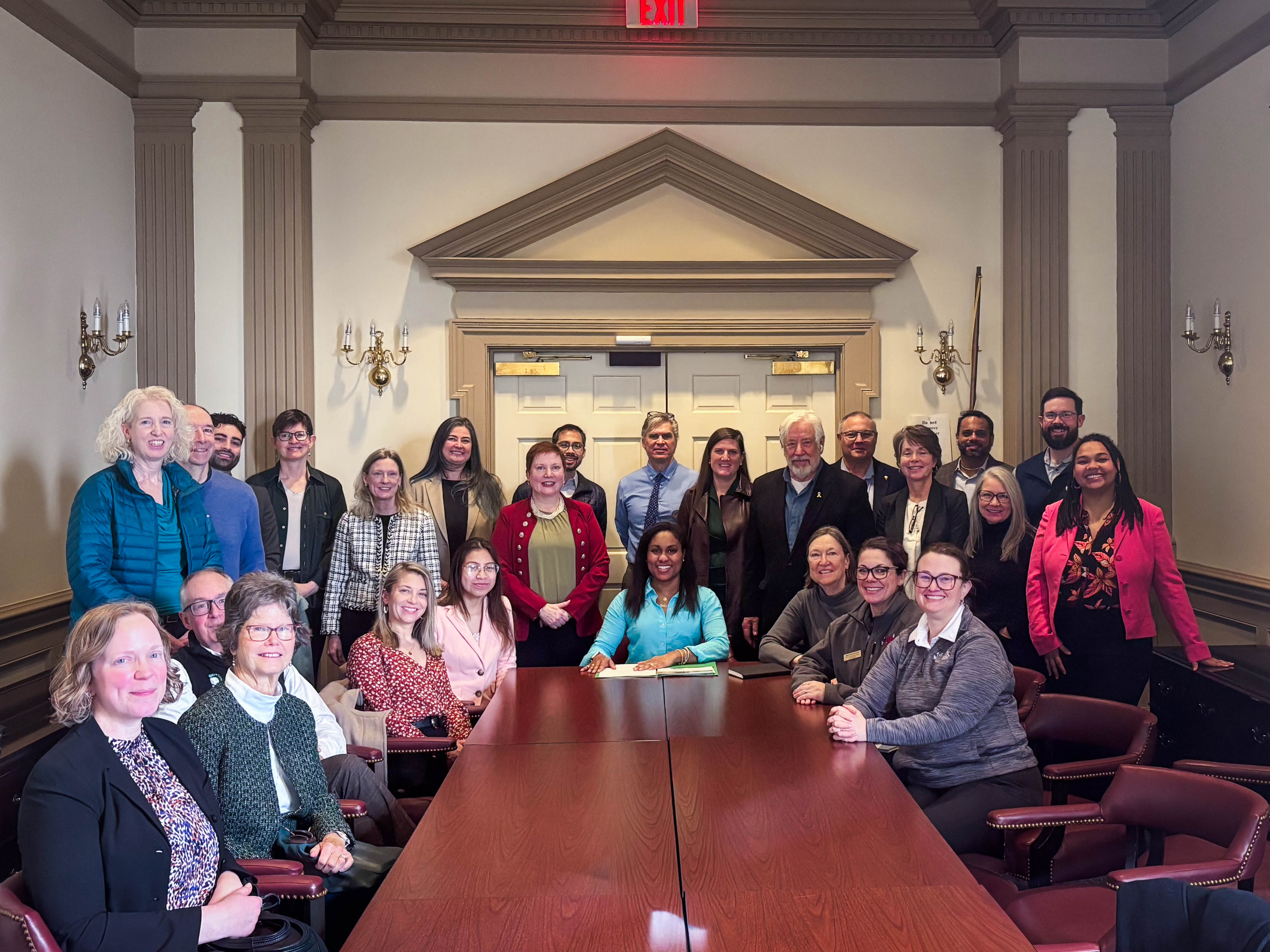 a large of group of people gather around a table at legislative hall during the 2026 conservation day in Dover.