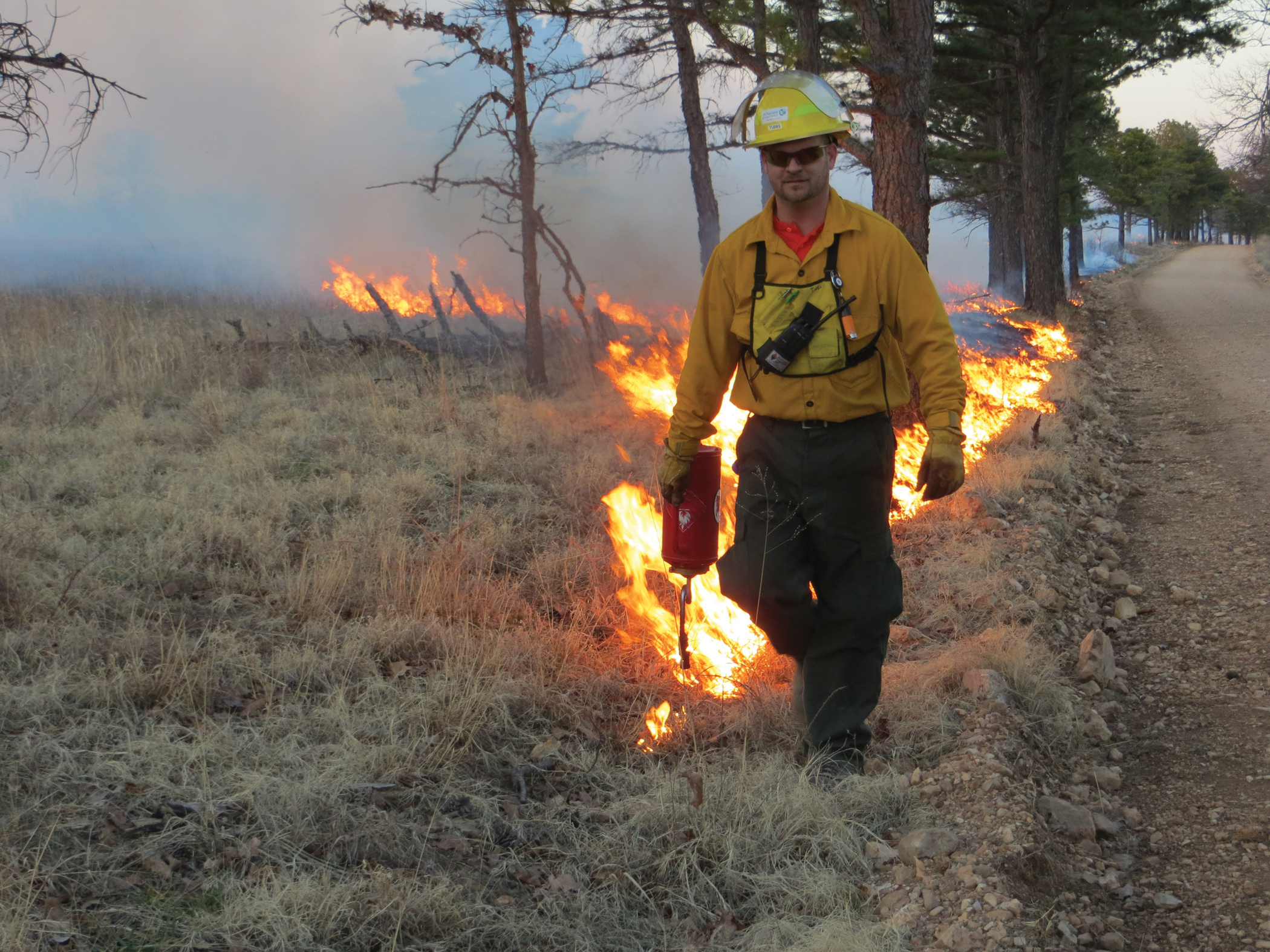 Jeremy Tubbs lights a fire using a drip torch during a prescribed burn at J.T. Nickel Family Nature and Wildlife Preserve.