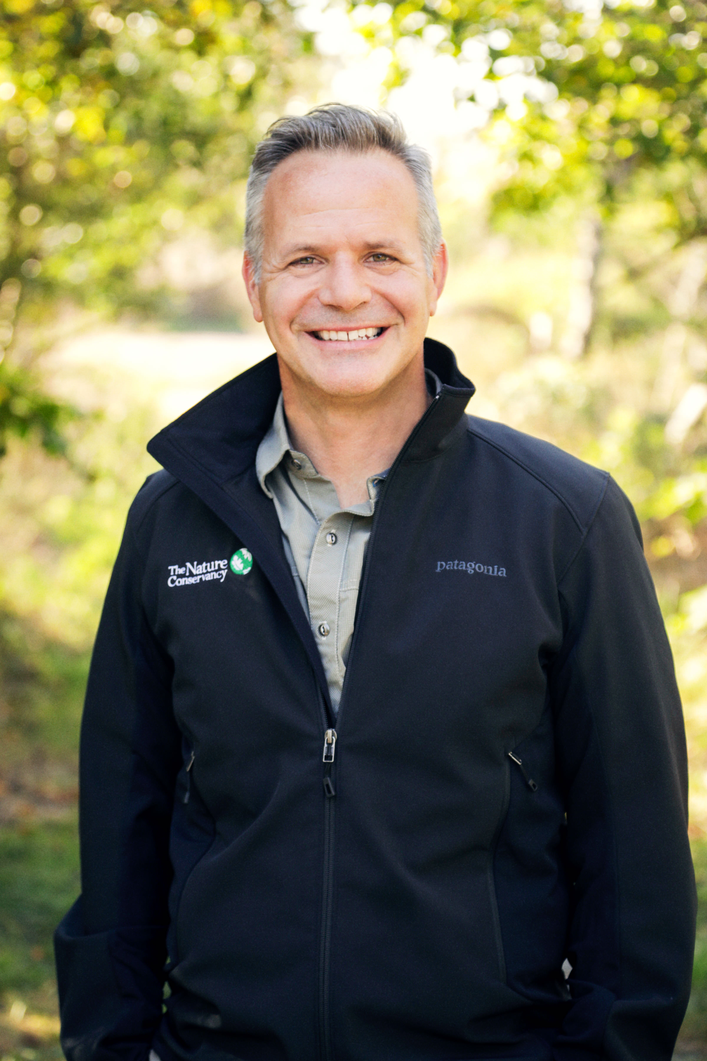 Man smiling at camera wearing a black jacket.