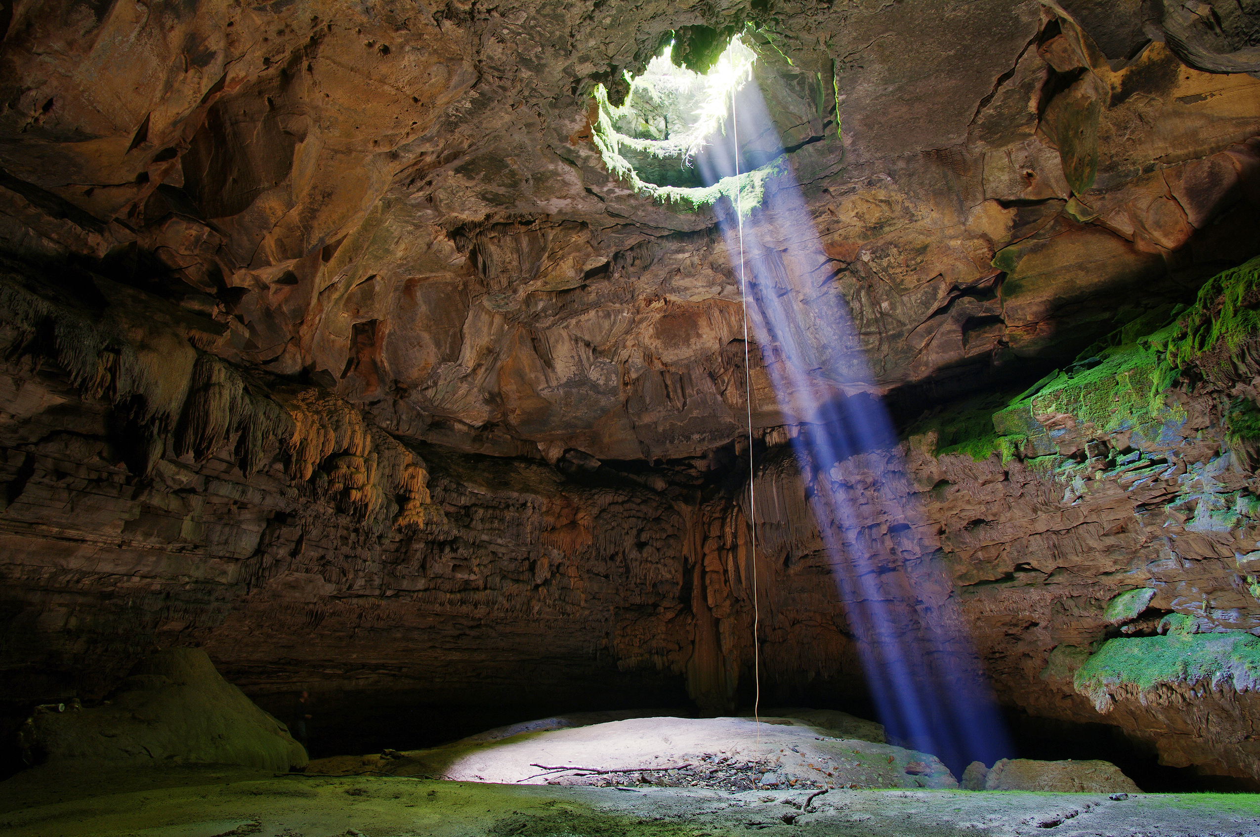 Beam of sunshine shining down into cave.