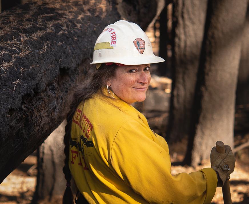Woman in yellow fire gear and white hardhat.