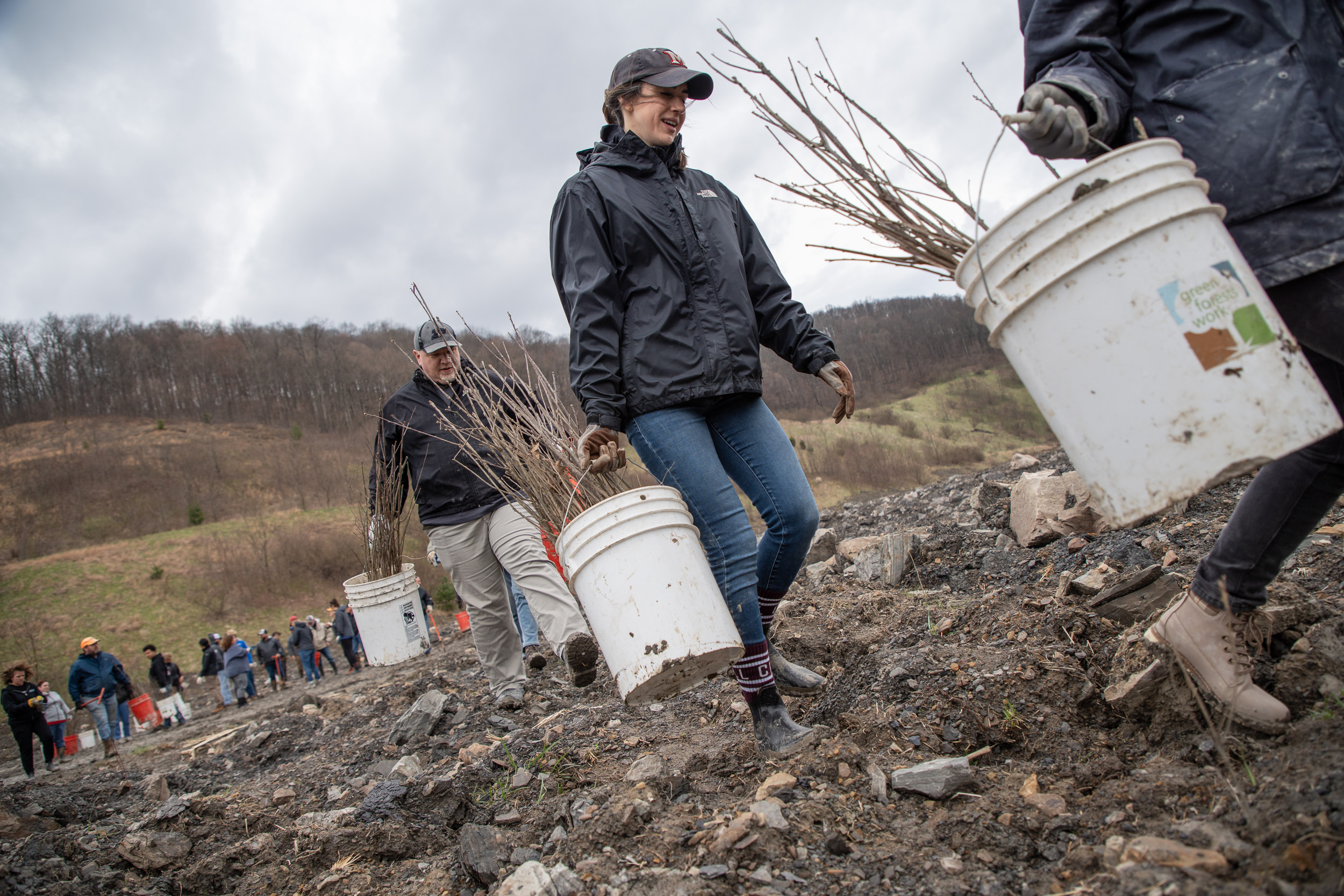 Volunteers walking and carrying white pails.