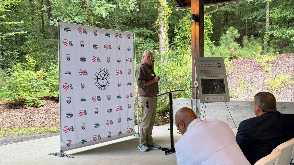 A man makes a presentation in front of a group. 