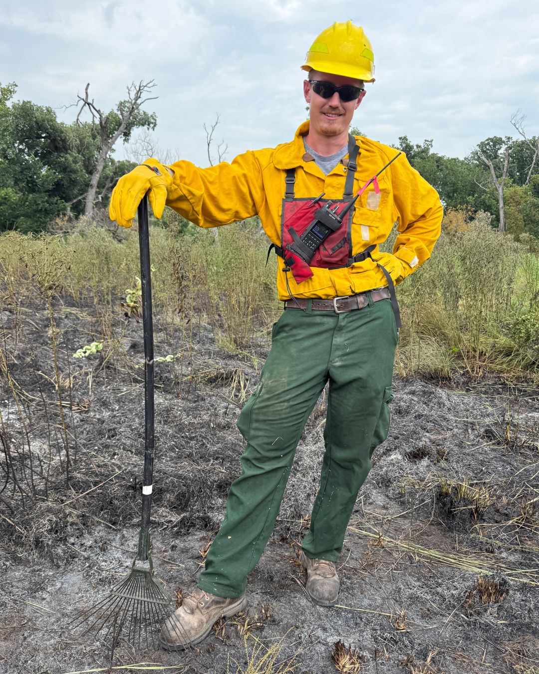 A man wearing a hard hat and yellow clothing features the type of gear needed to perform prescribed burns.