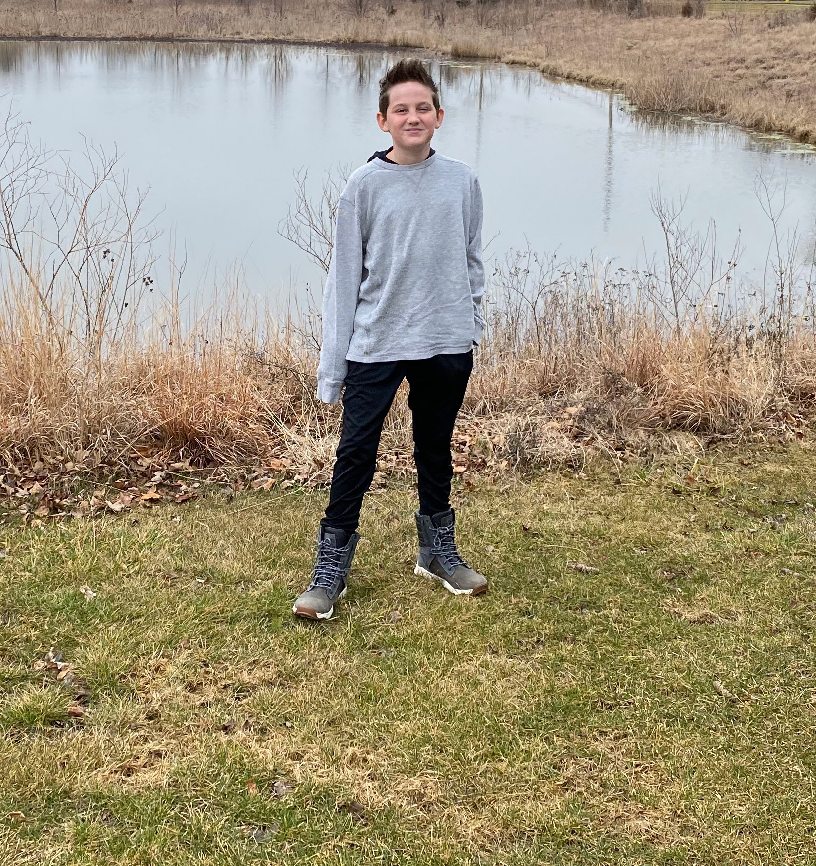 Young person stands next to an isolated wetland.