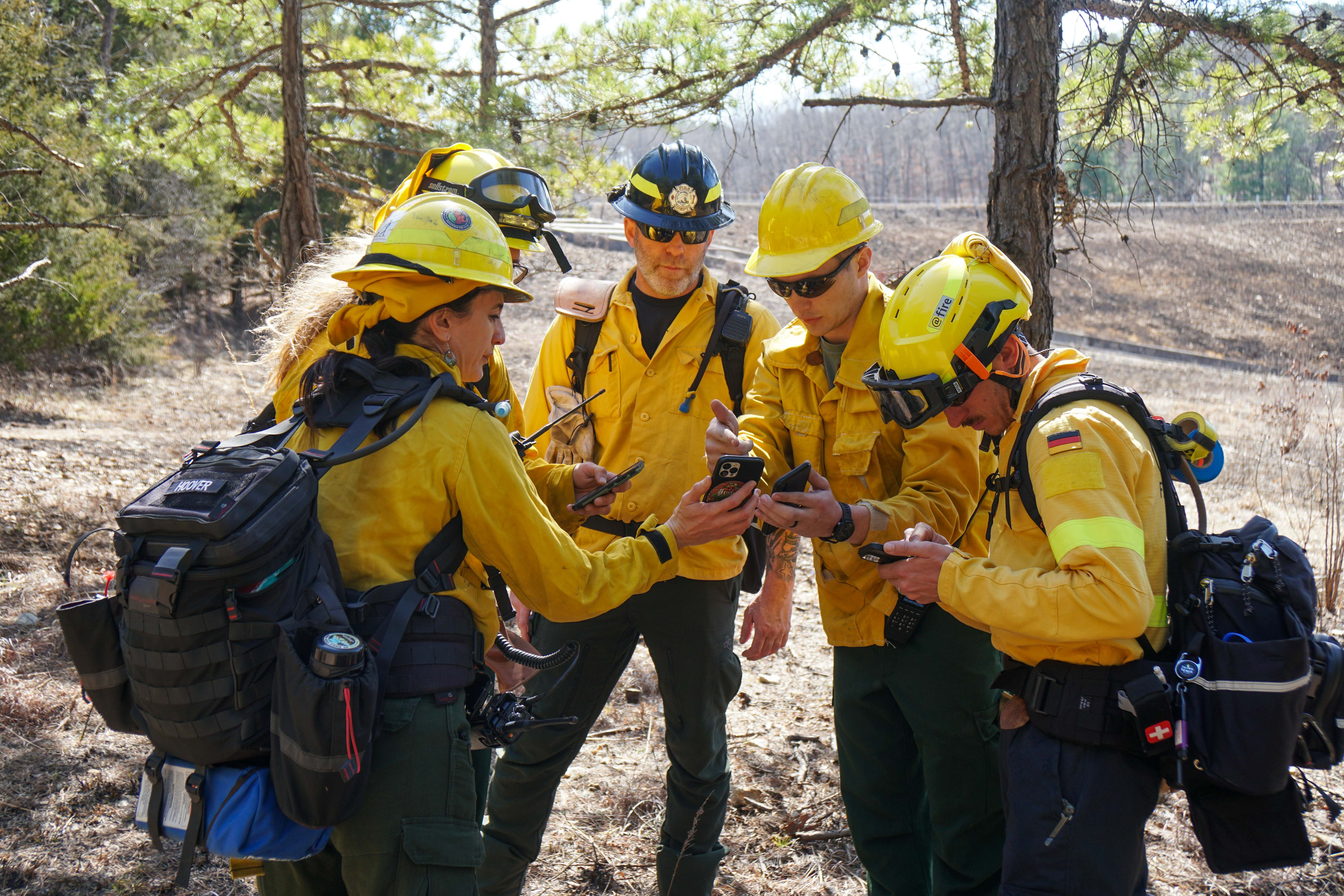 Four wildland fire practitioners discuss an upcoming controlled burn and training event.