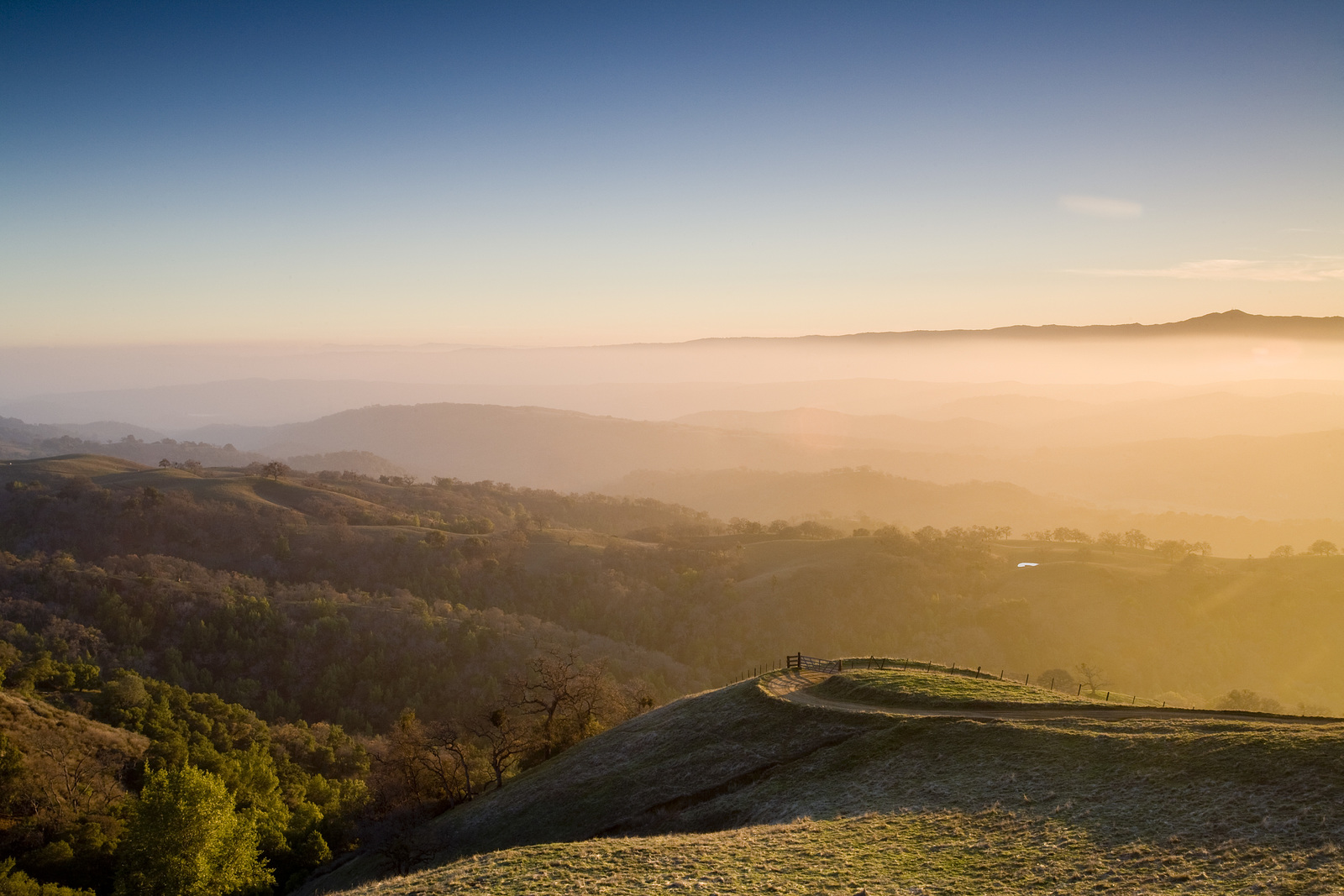 View looking across a hilly landscape at sunset.