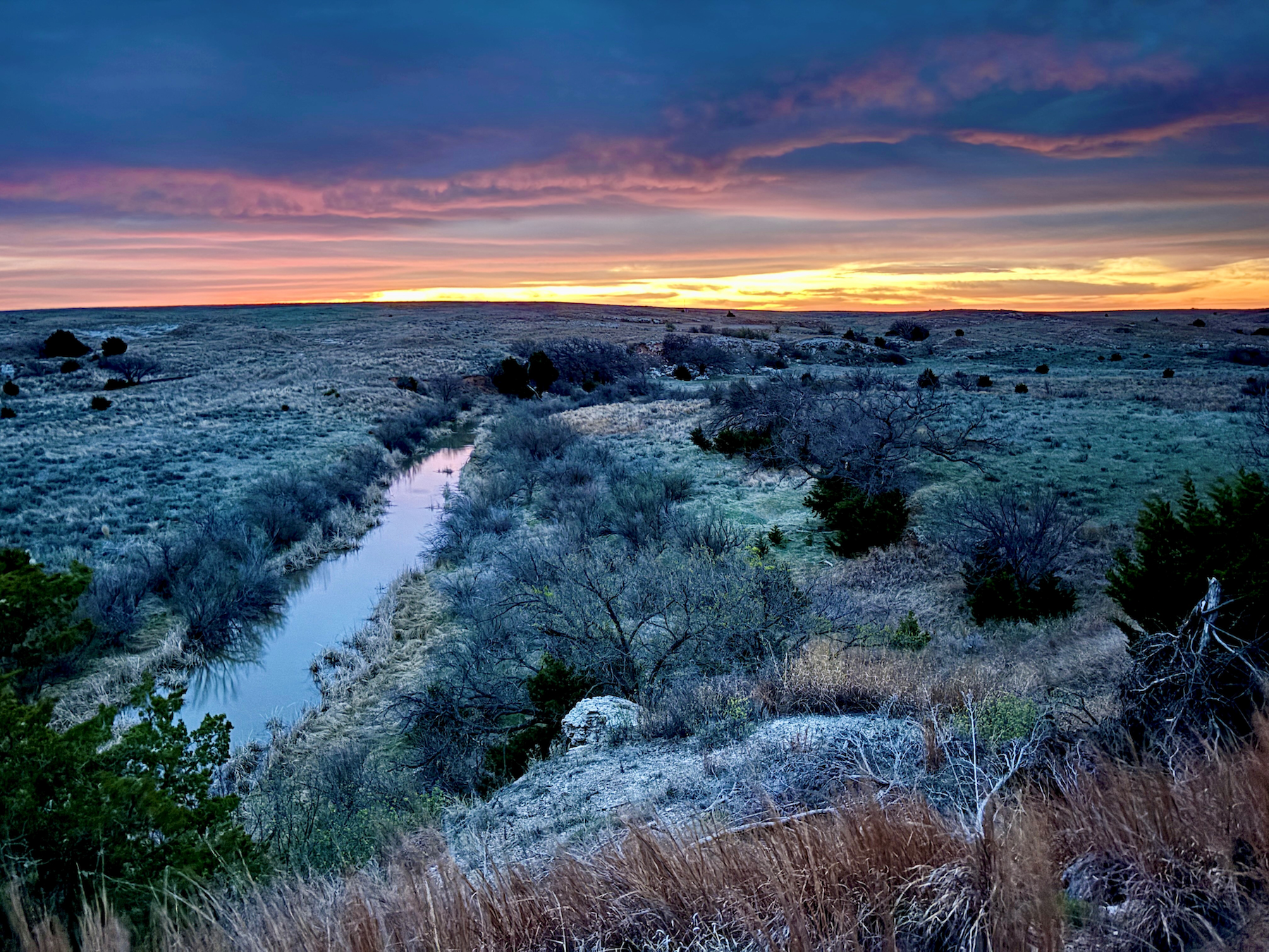 The sun setting over the Sand Creek Ranch painting the sky beatiful colors.