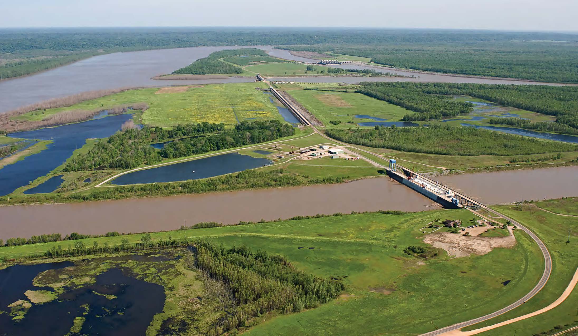 An aerial image features a mix of wetlands and channelized river.