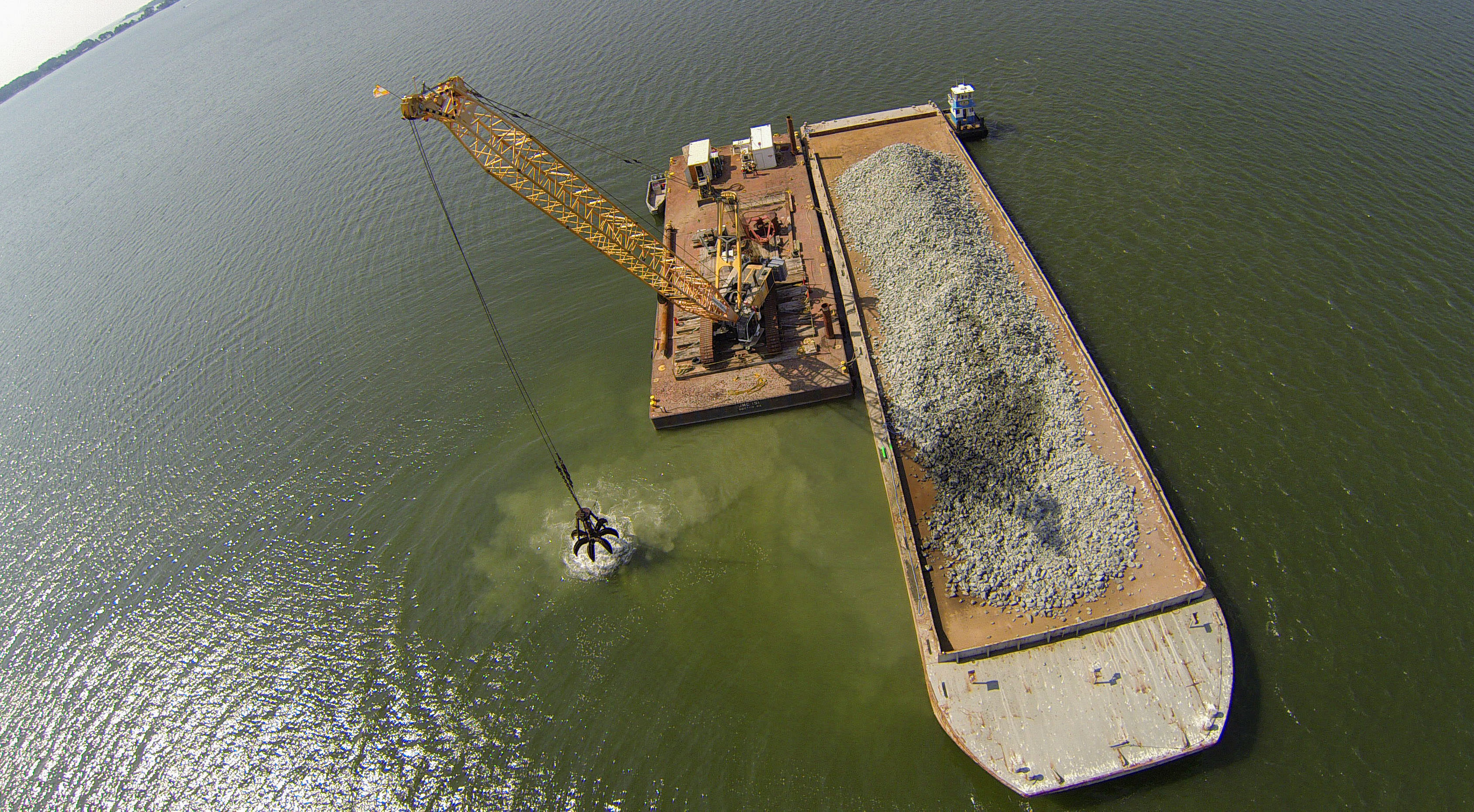 Aerial view of floating barge full of crushed granite.