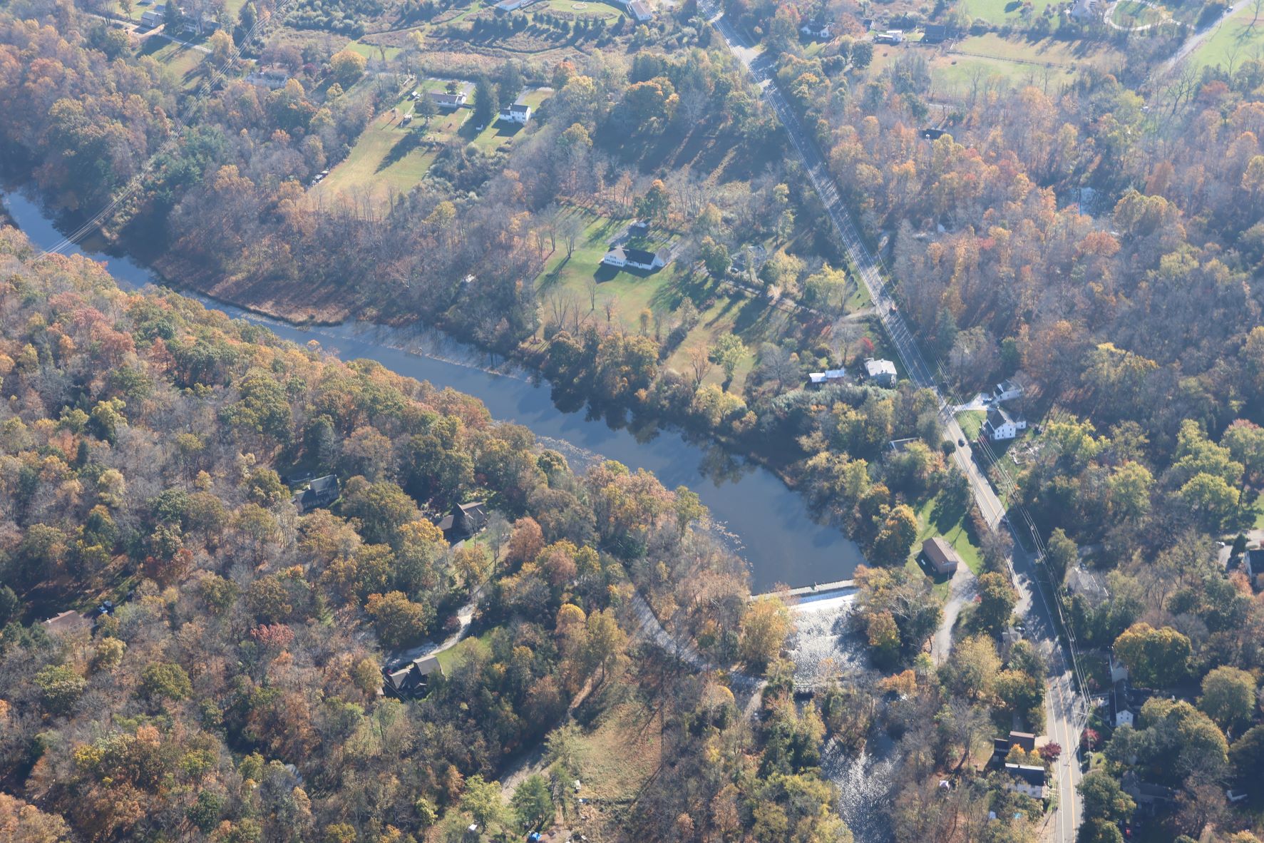 Aerial view of a winding river obstructed by a dam.