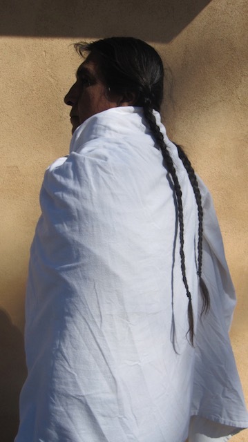 Native American man with long braids wrapped in white.