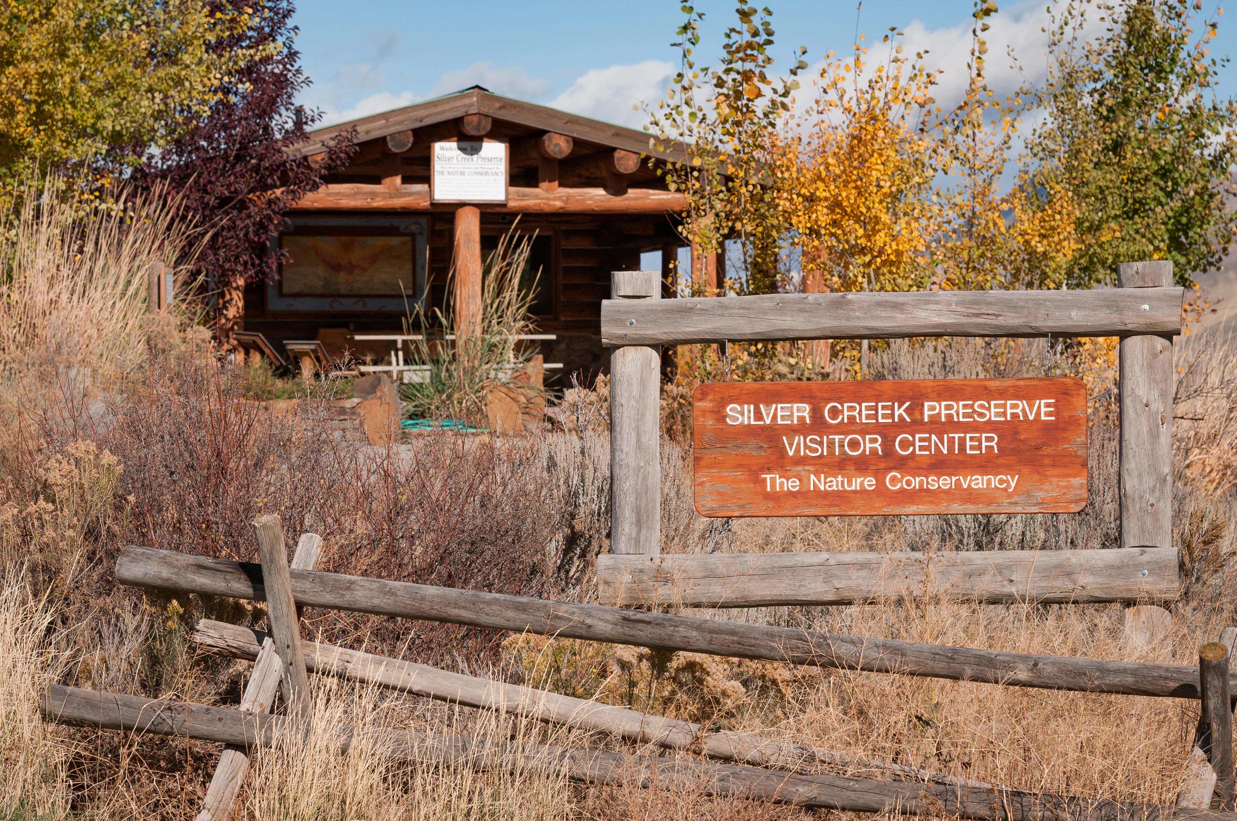 Visitor center building surrounded by shrubs and trees.