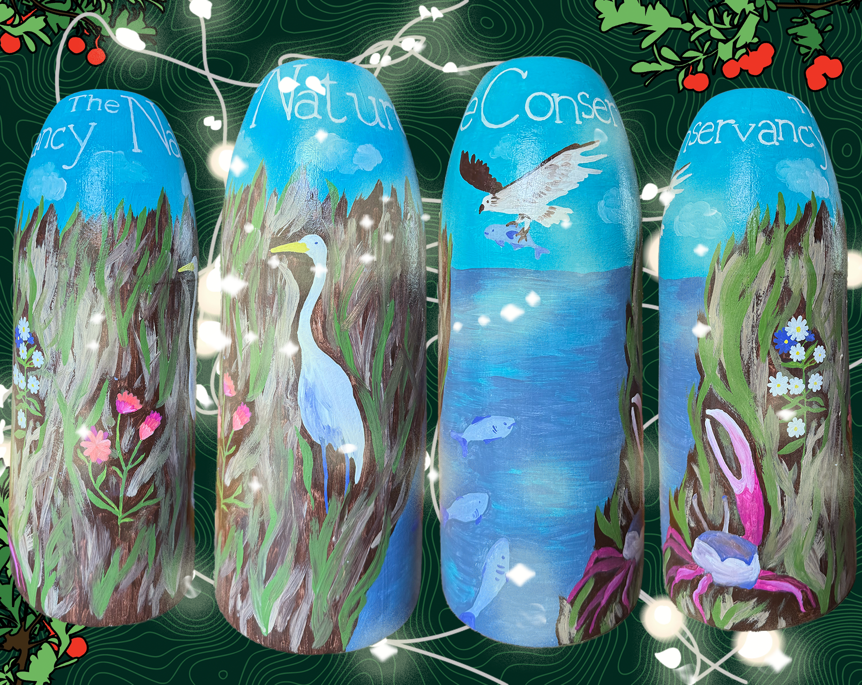 Four lobster buoys are decorated with art depicting a salt marsh. 