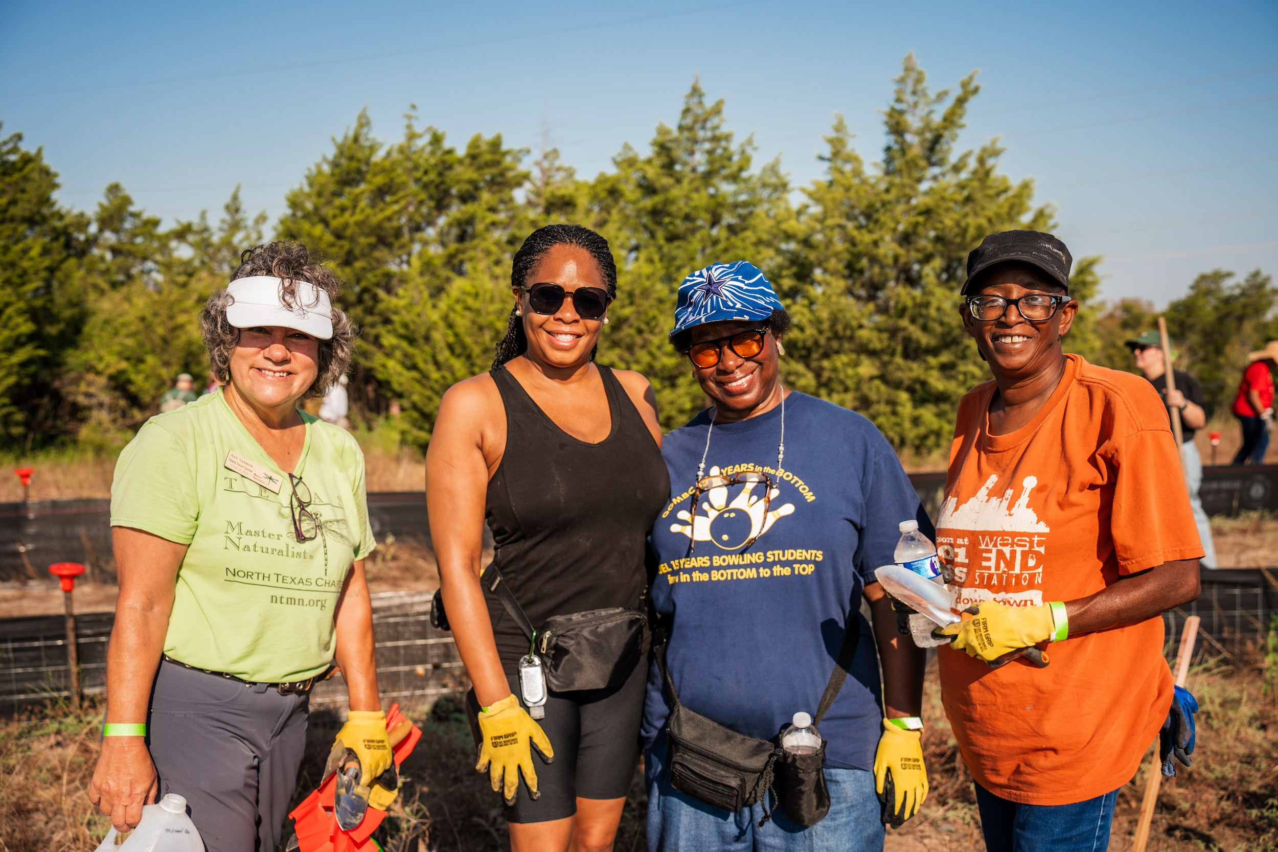 Group of people in prairie field smiling at camera. 