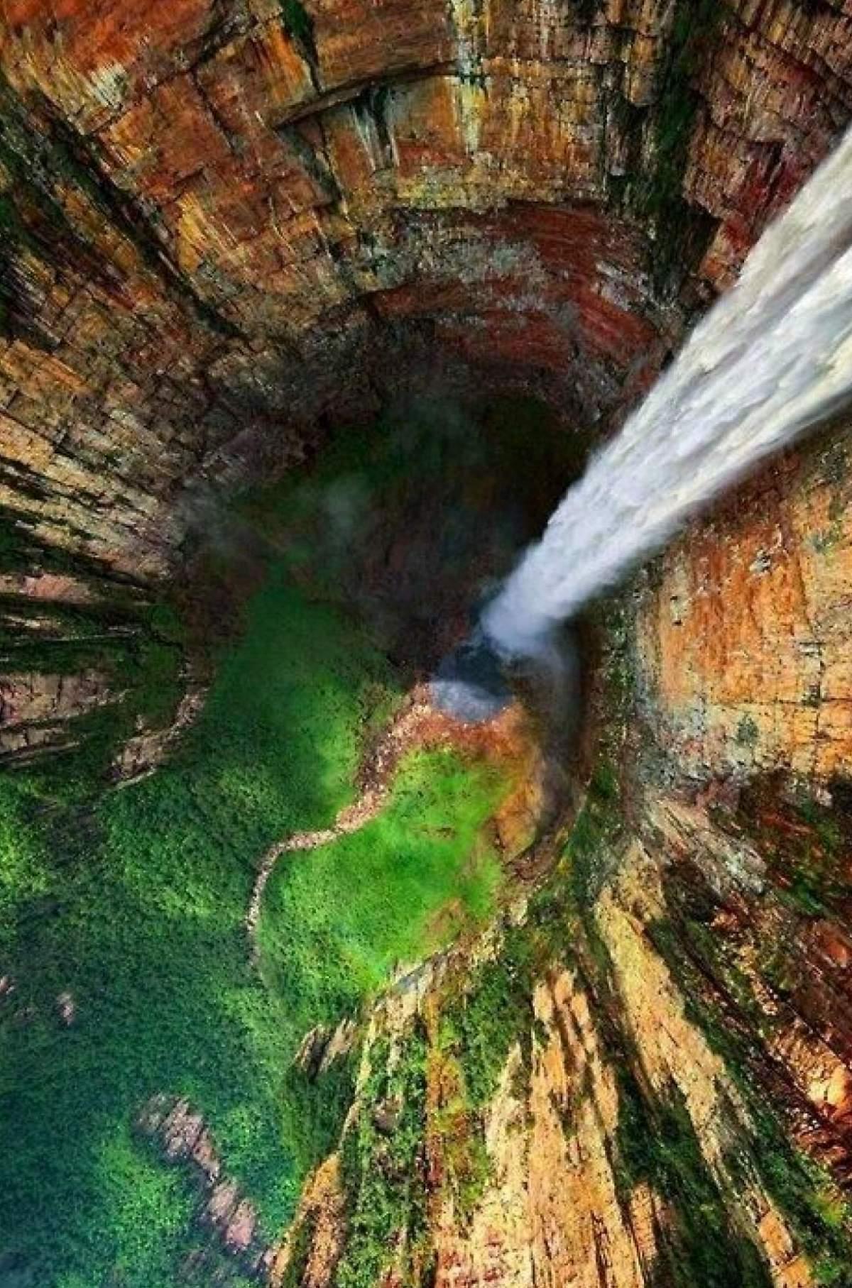 View from atop a very tall waterfall looking down toward the ground.