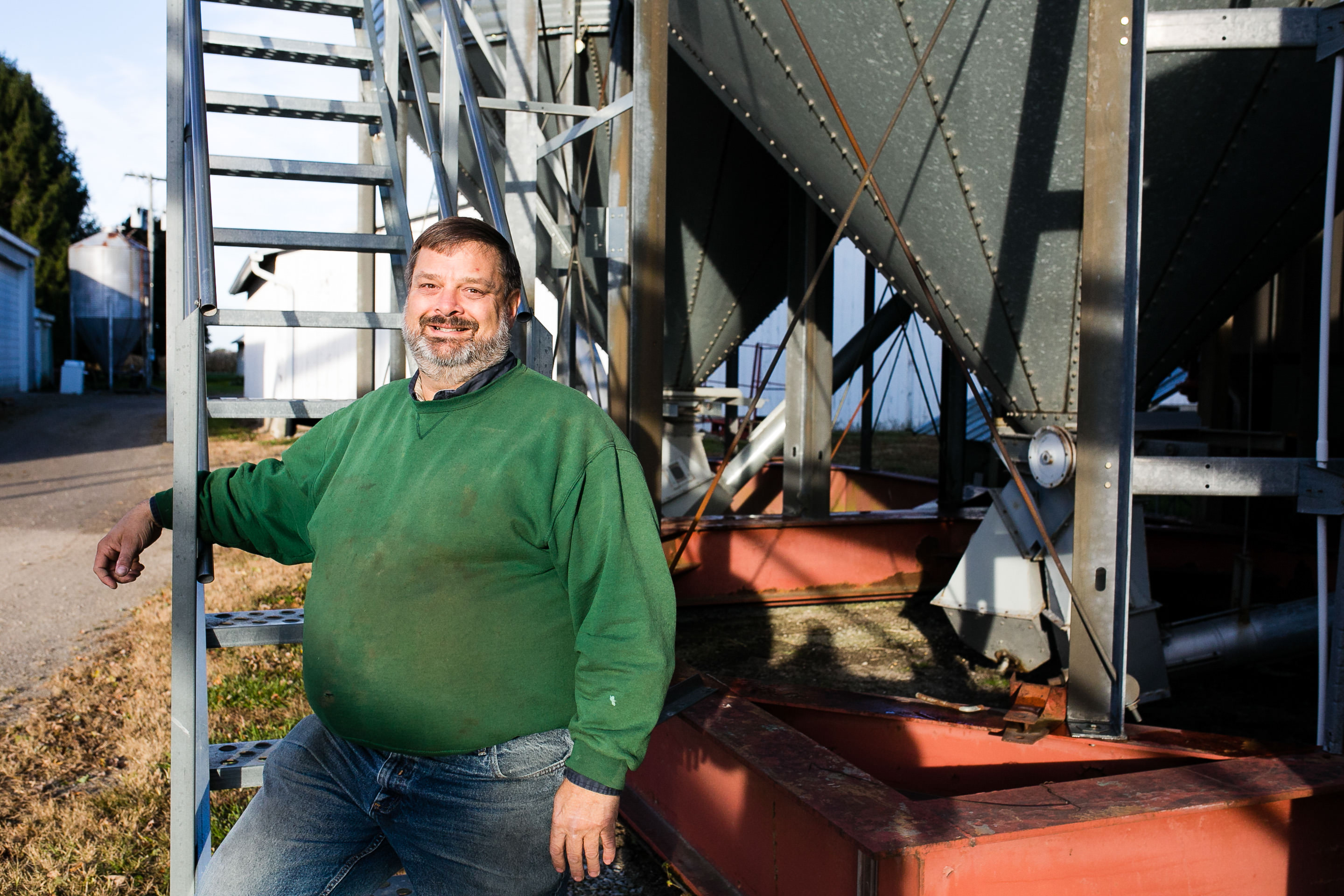 Farmer Todd Hesterman stands next to farm equipment.