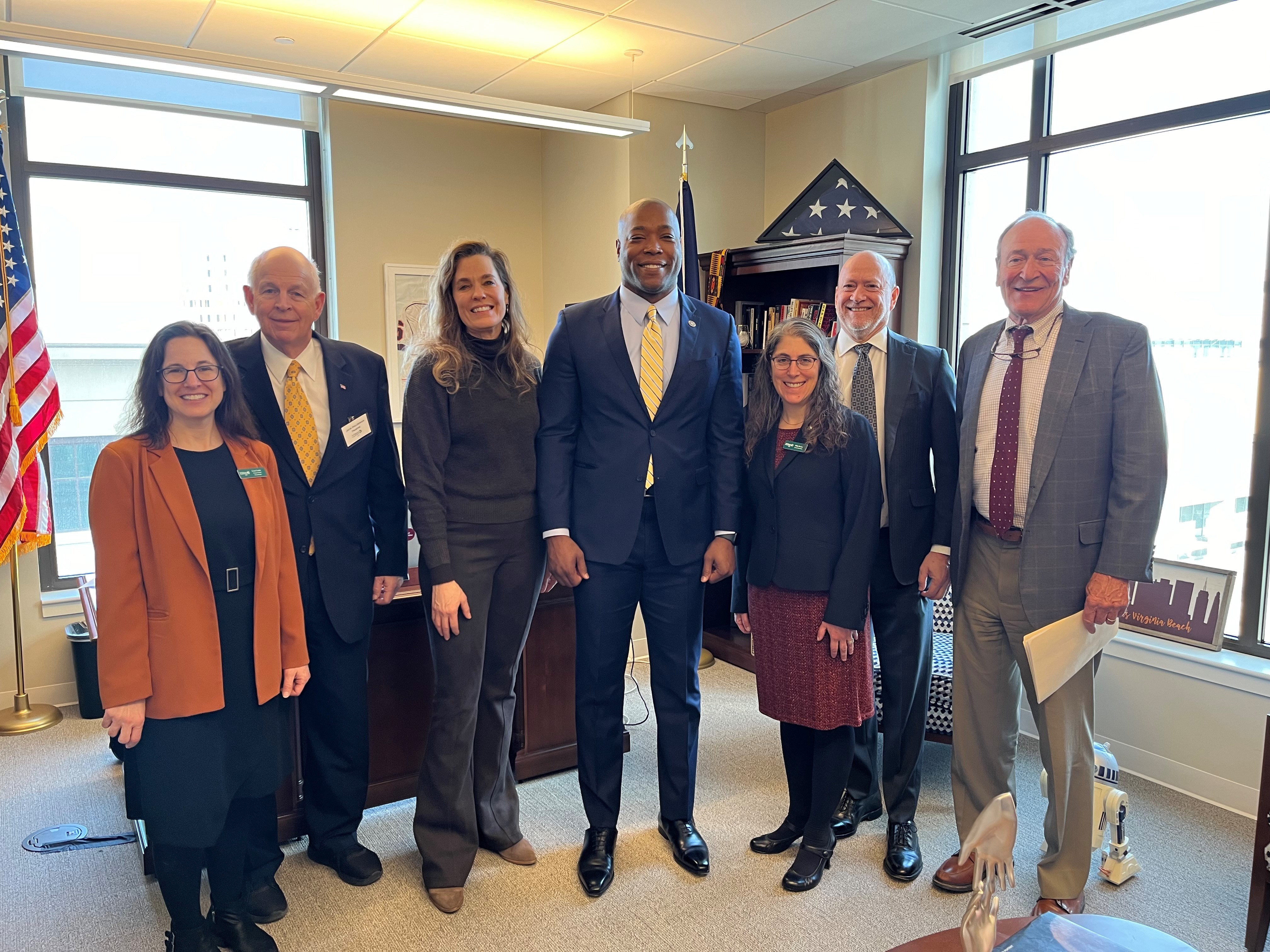 Staff members and trustees standing with Senator Aaron Rouse.