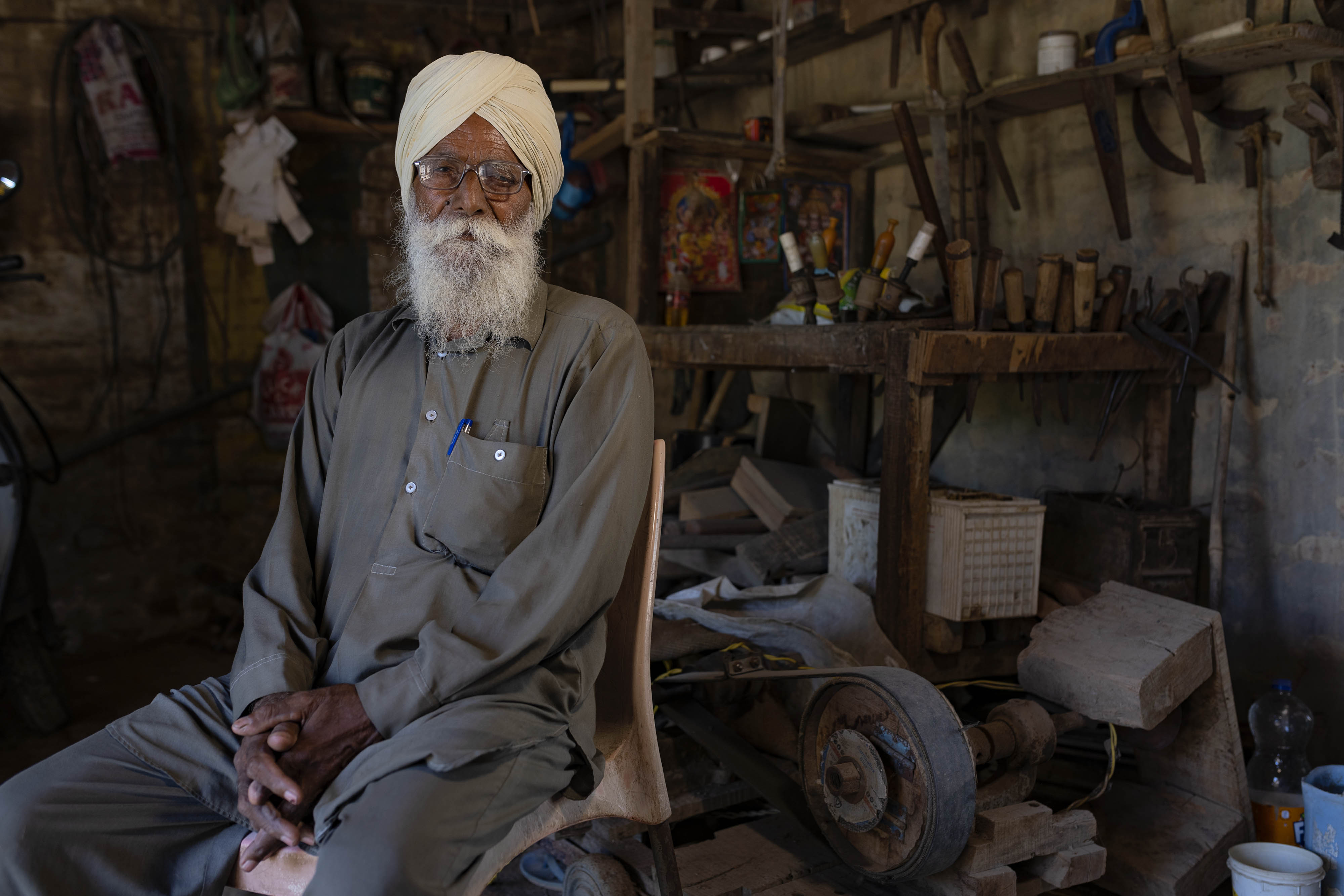 A portrait of Sardar Amar Singh as he sits in a room full of equipment.