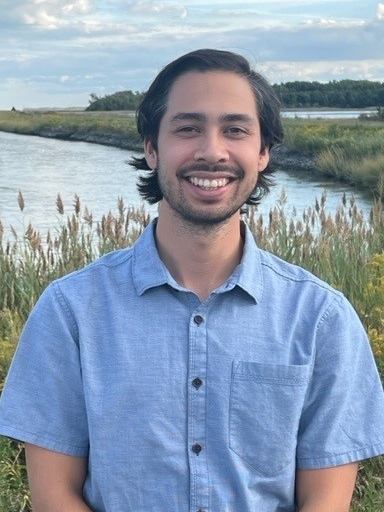 A headshot of Will Helt in front of a marsh.