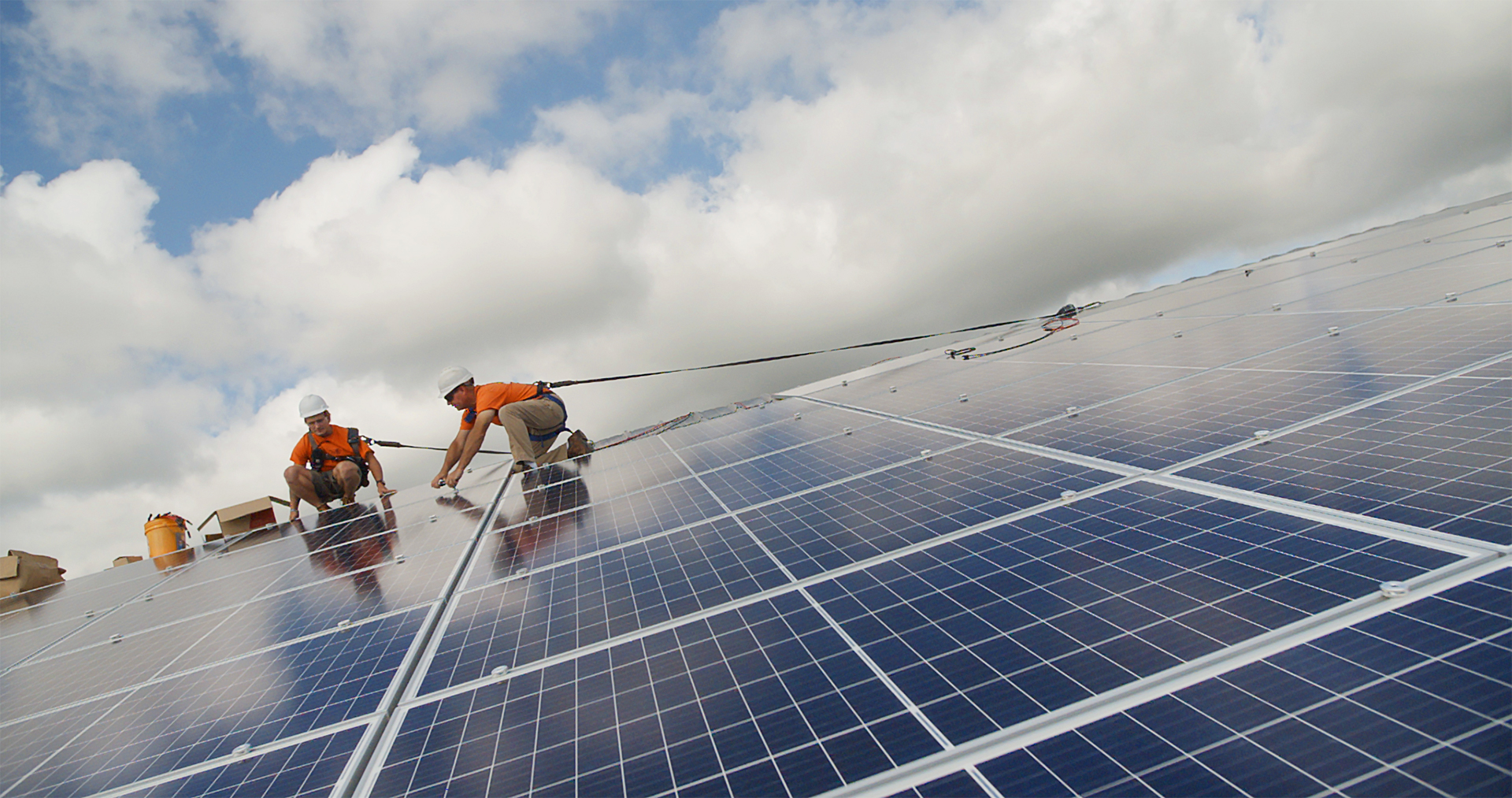 Two men installing solar panels.