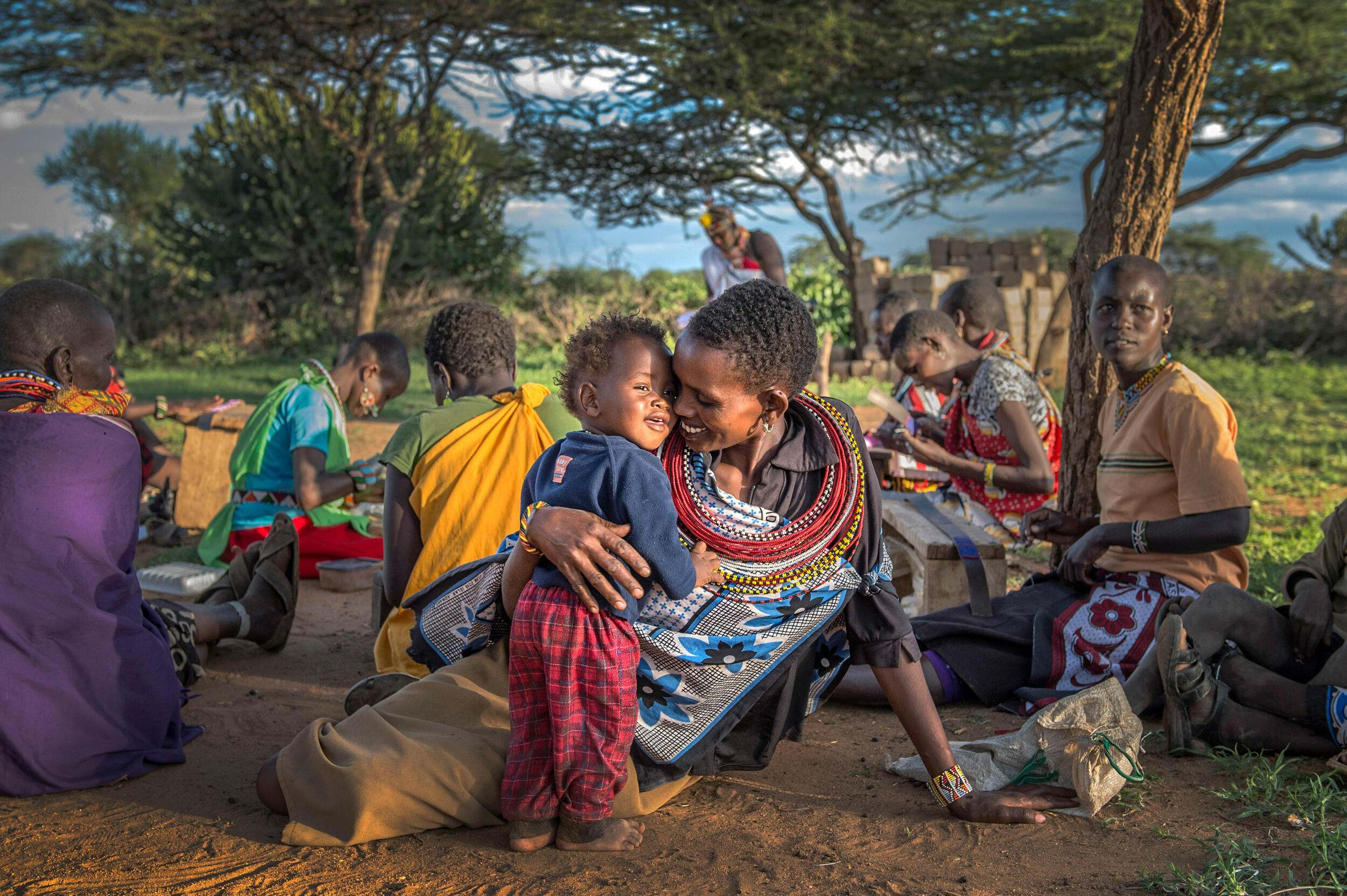 Ntipiyon Nonguta and her son Bernard, 1, rest in the shade of a tree in Ewaso Village, Kenya, in 2015. Nonguta made and sold handicrafts through BeadWORKS.